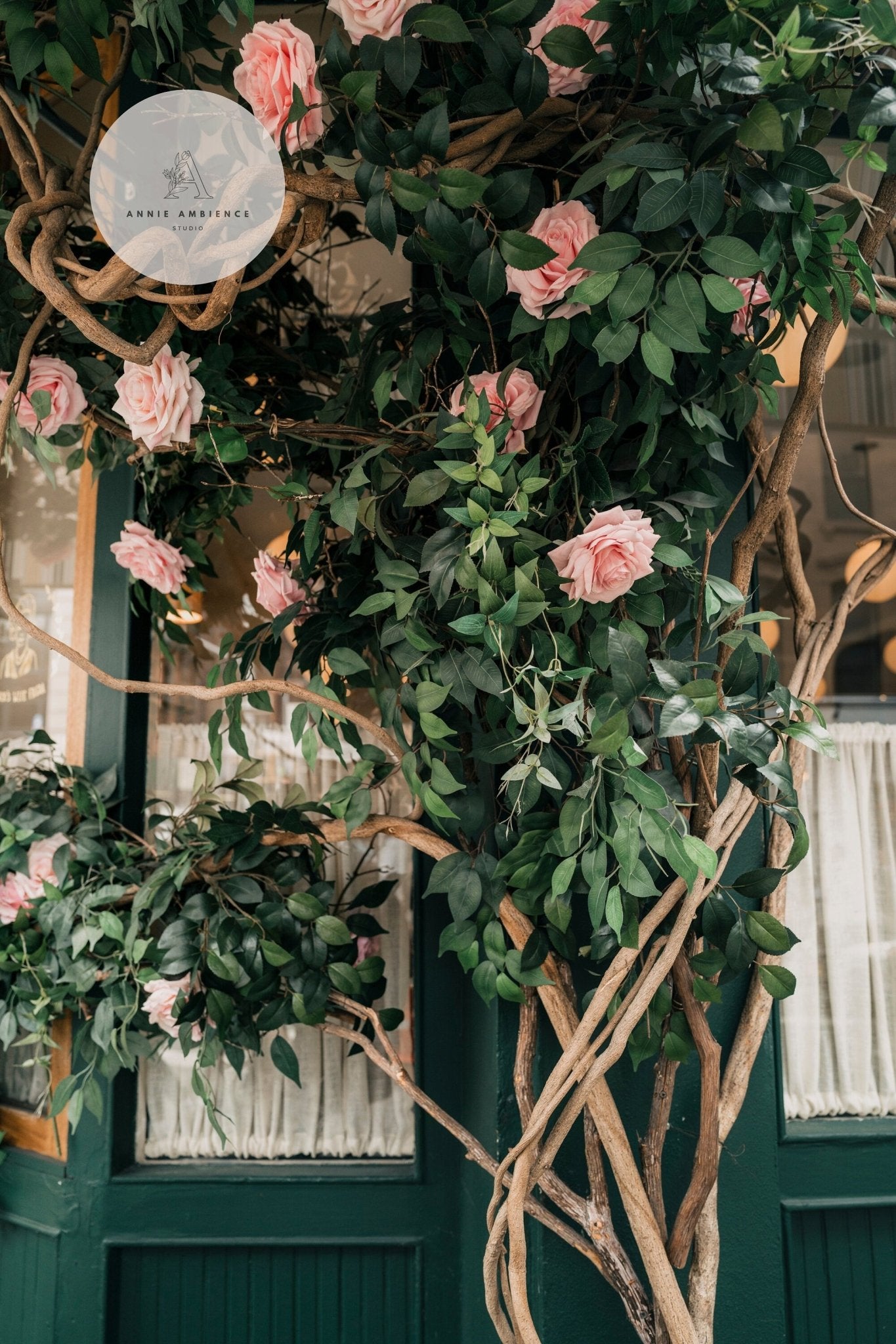 The Rose Vine decorates the storefront with pink roses and green leaves intertwined in wooden branches.