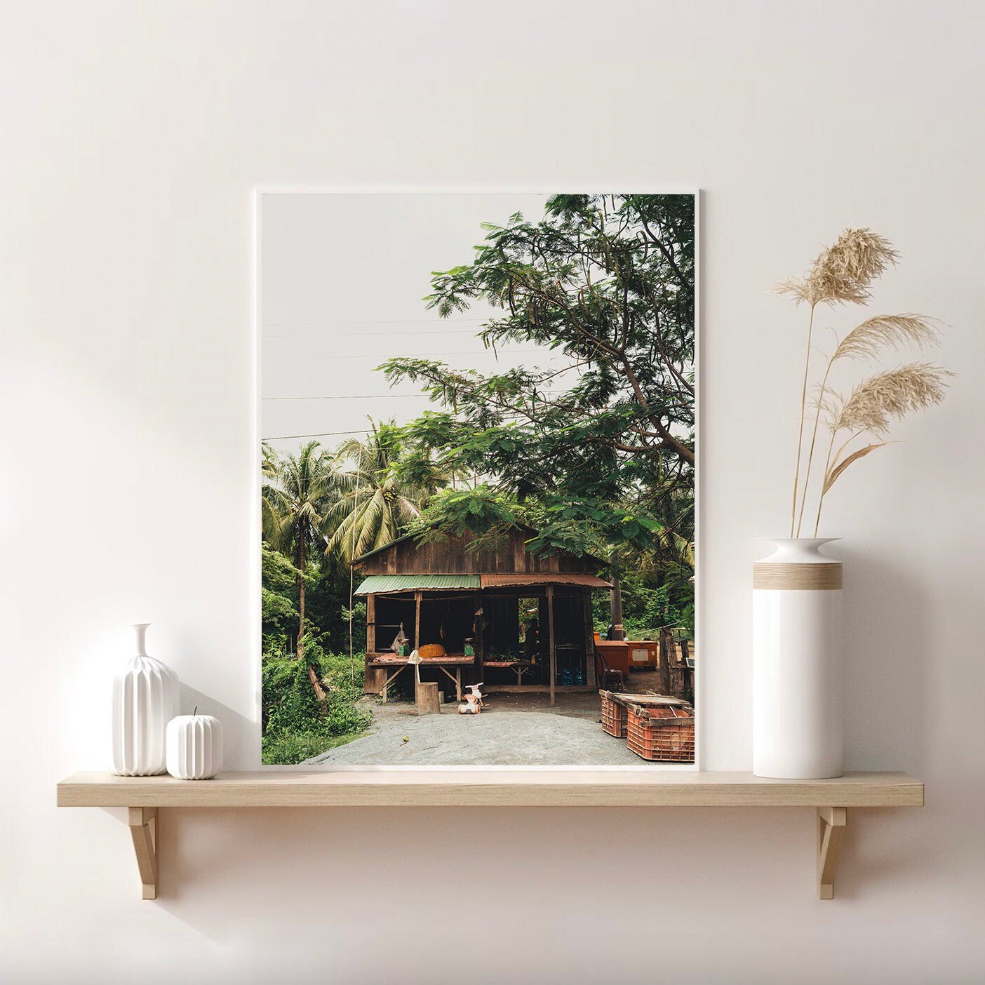 Rural Shop framed photo with greenery, on a shelf with vases and dried grasses.