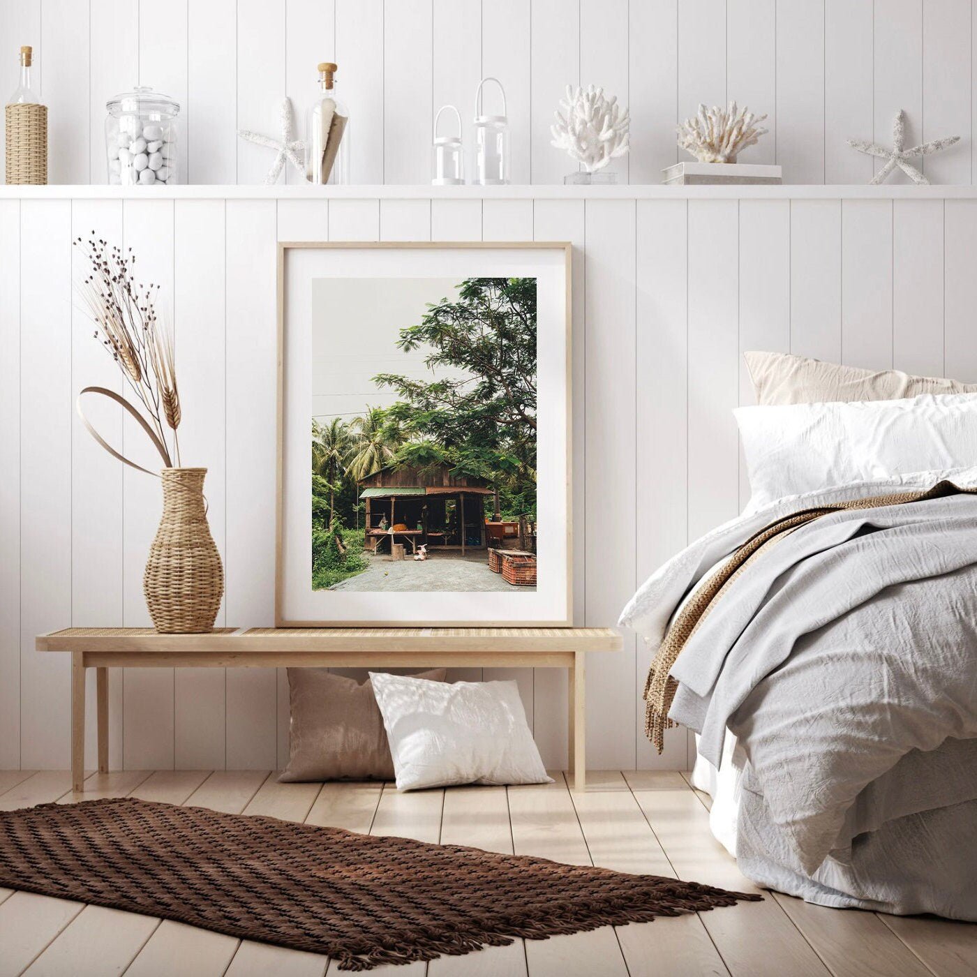 A cozy bedroom with a wooden bench, rustic decor, and Rural Shop framed picture of a house with greenery on the wall.