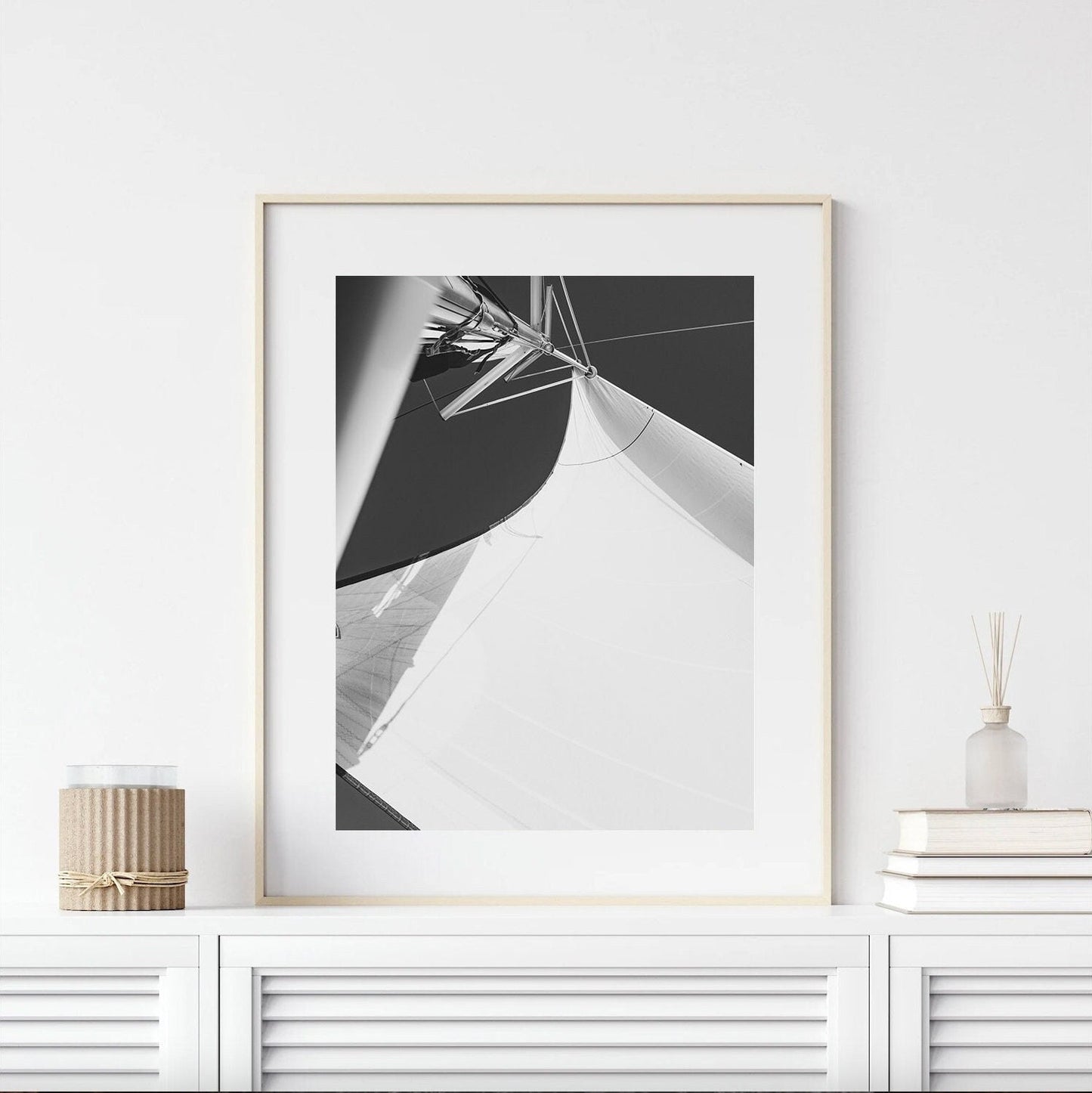 Sailing Bliss II Black & White photo of a sailboats sails, framed and displayed on a white shelf with minimalistic decor.