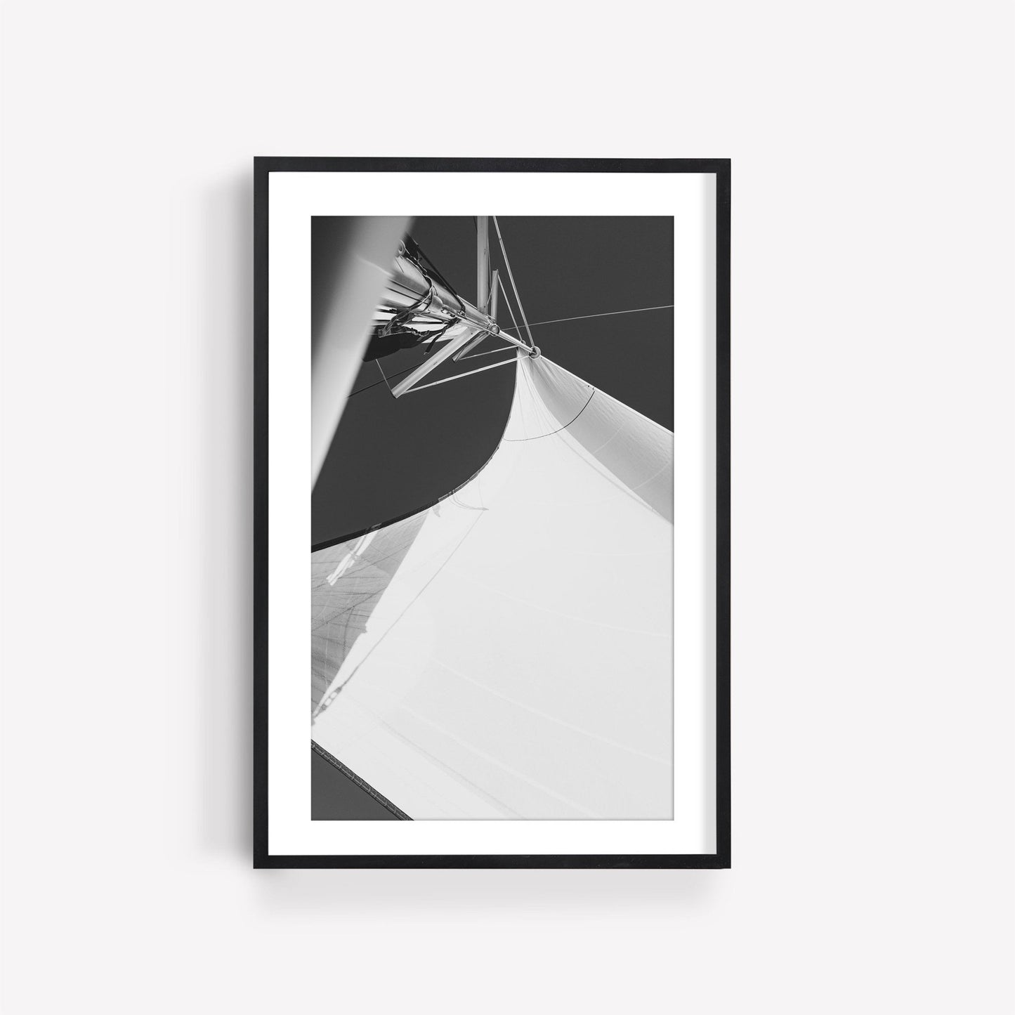 Sailing Bliss II Black and White photo of a sail on a boat, framed against a plain white wall.