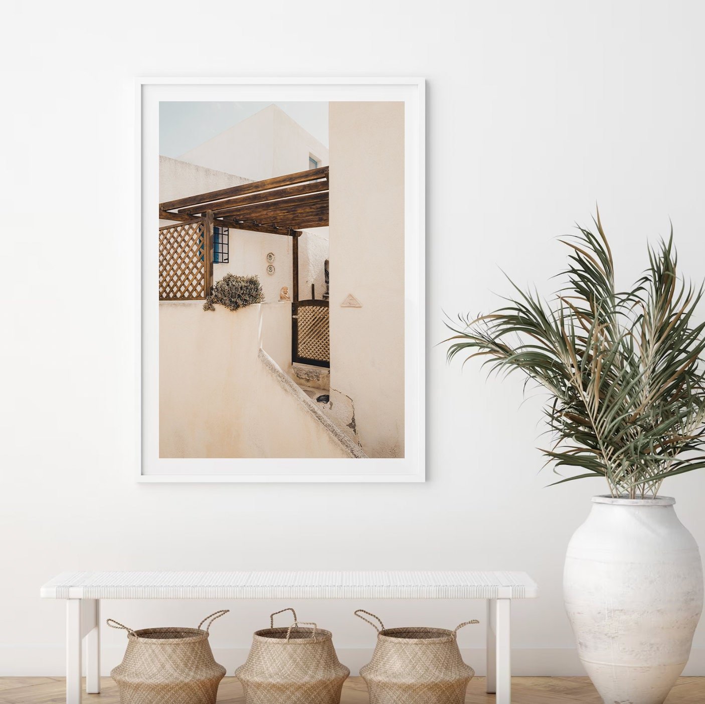 Minimalist interior featuring Sand Serenity, a white bench, woven baskets, and a large potted plant against a white wall.