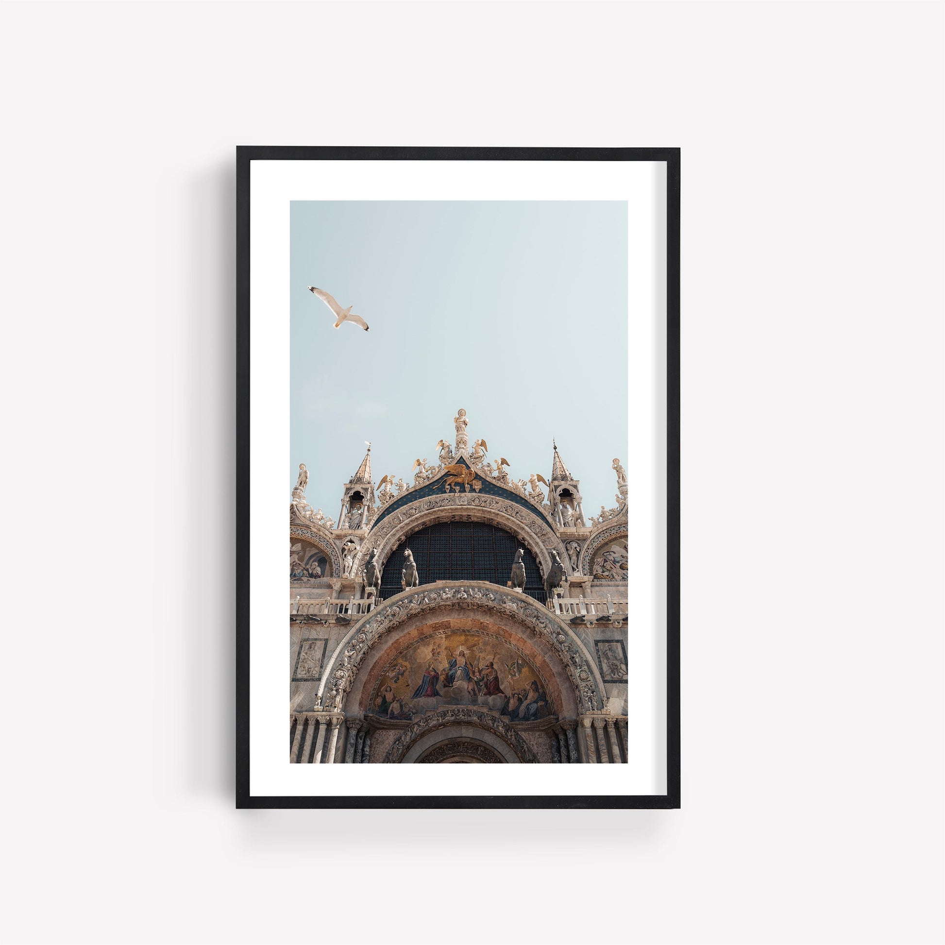 Framed photo of St. Marks Basilica facade with a flying bird against a pale sky.
