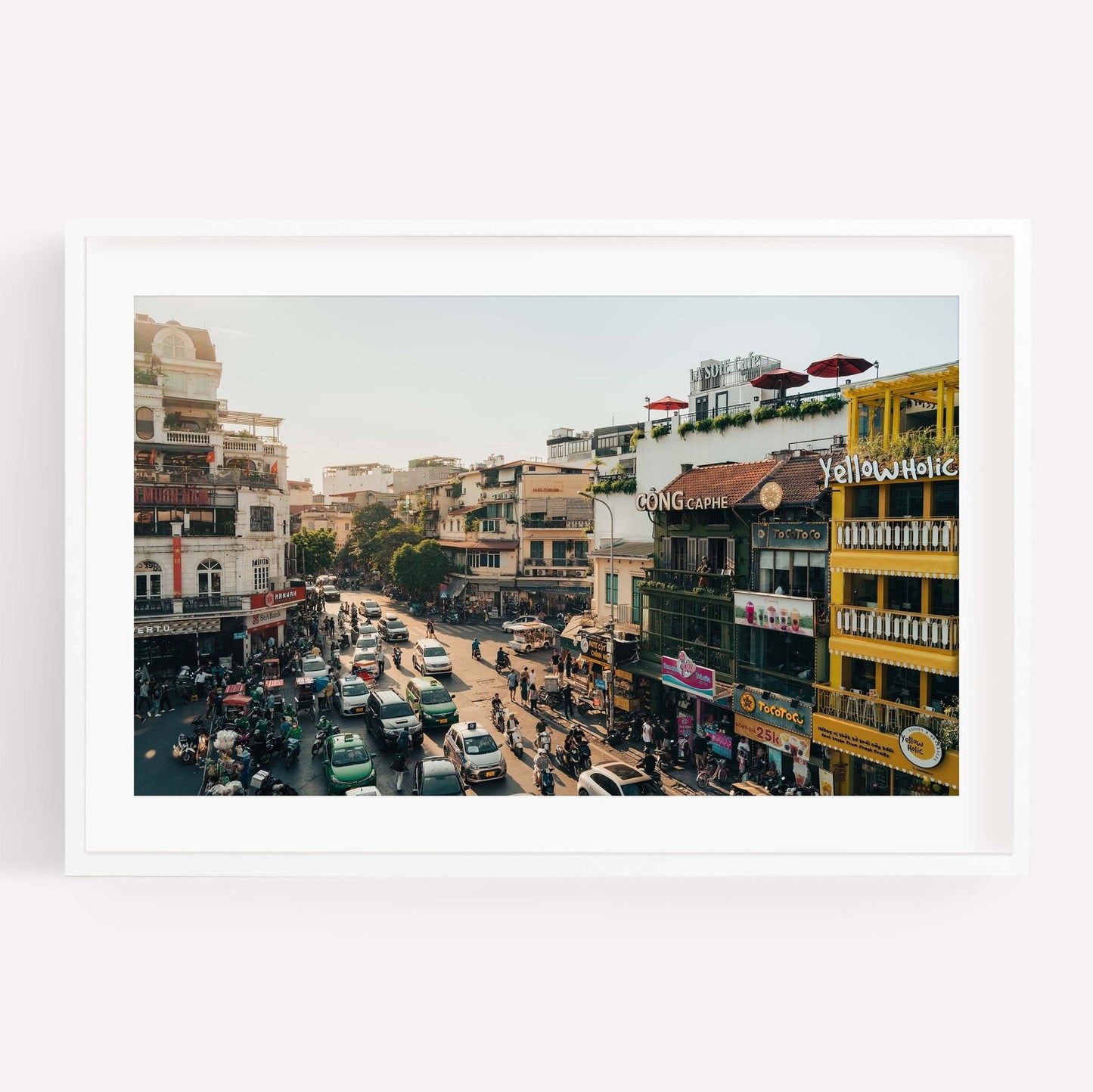 Streets of Hanoi captures a bustling city street with colorful buildings and busy traffic in daylight.