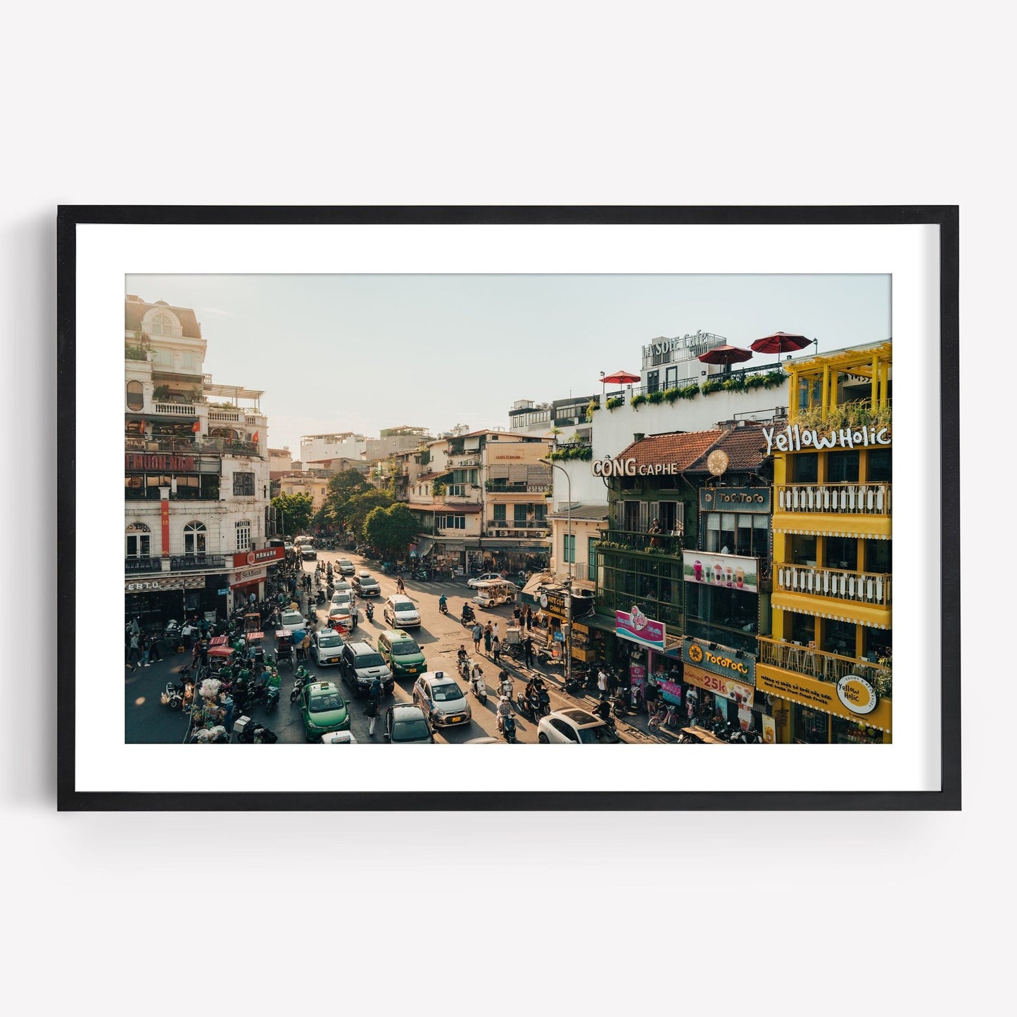 Streets of Hanoi: Framed photo of a lively city street with vibrant buildings and busy traffic on a sunny day.