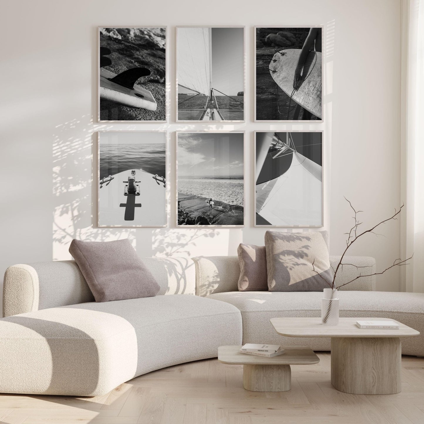 Minimalist living room with a curved white sofa, light wood tables, and Surf and Sail Black and White - Set of 6 on the wall.