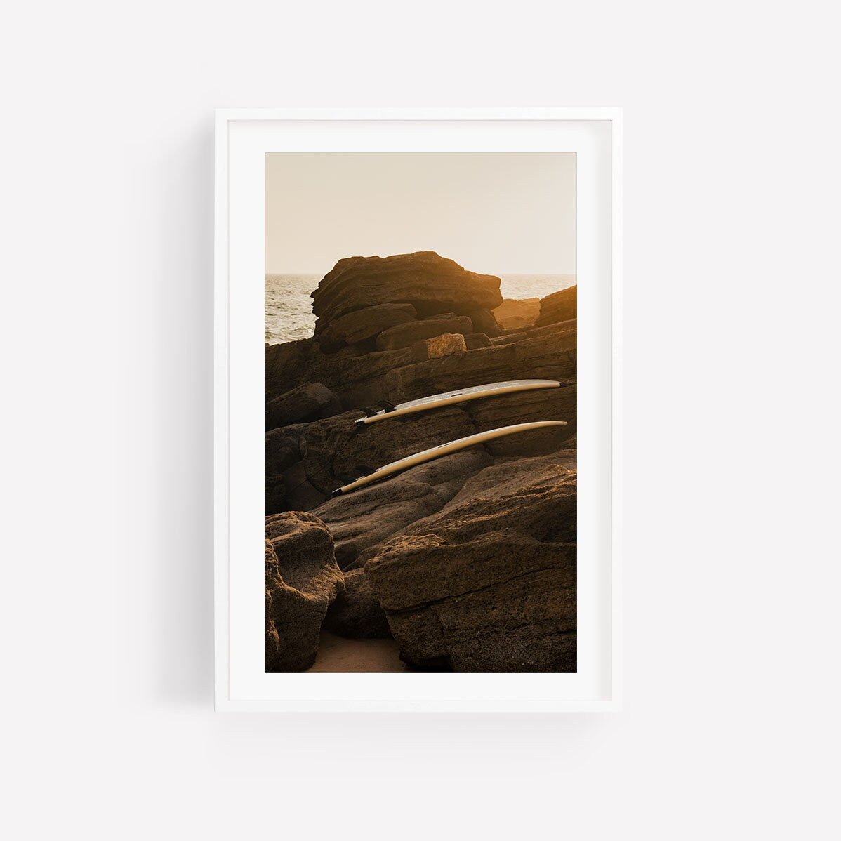 Taghazout Sunset - Set of 3: Framed rocky shoreline photo with gentle waves and warm golden light at sunset.
