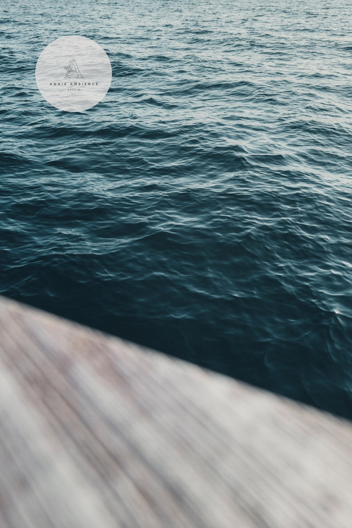 Teal Ocean - Set of 3: A view of calm ocean waves with a blurred wooden surface in the foreground.