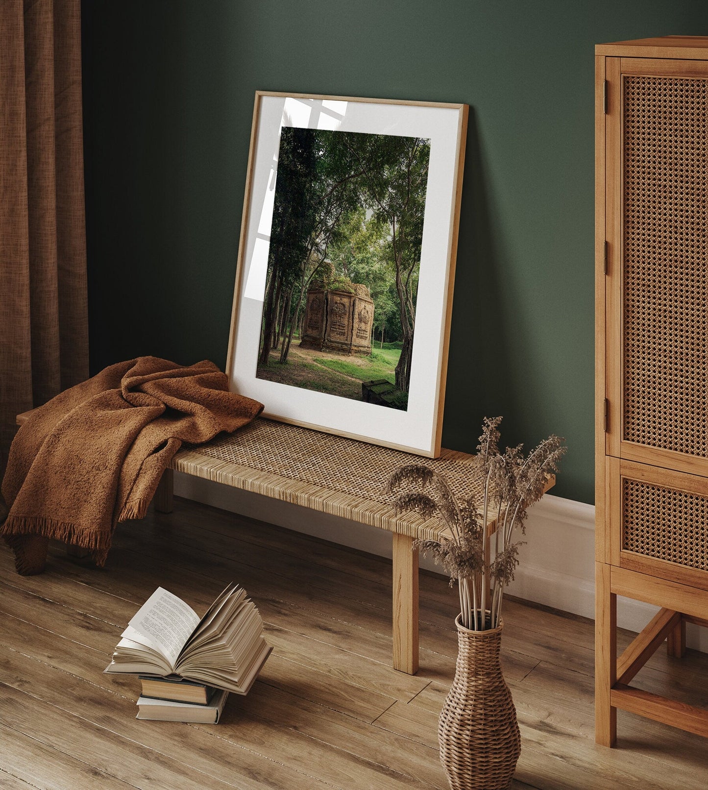 The Temple I framed nature photo rests on a wooden bench with a blanket, next to a book and dried flowers on the floor.