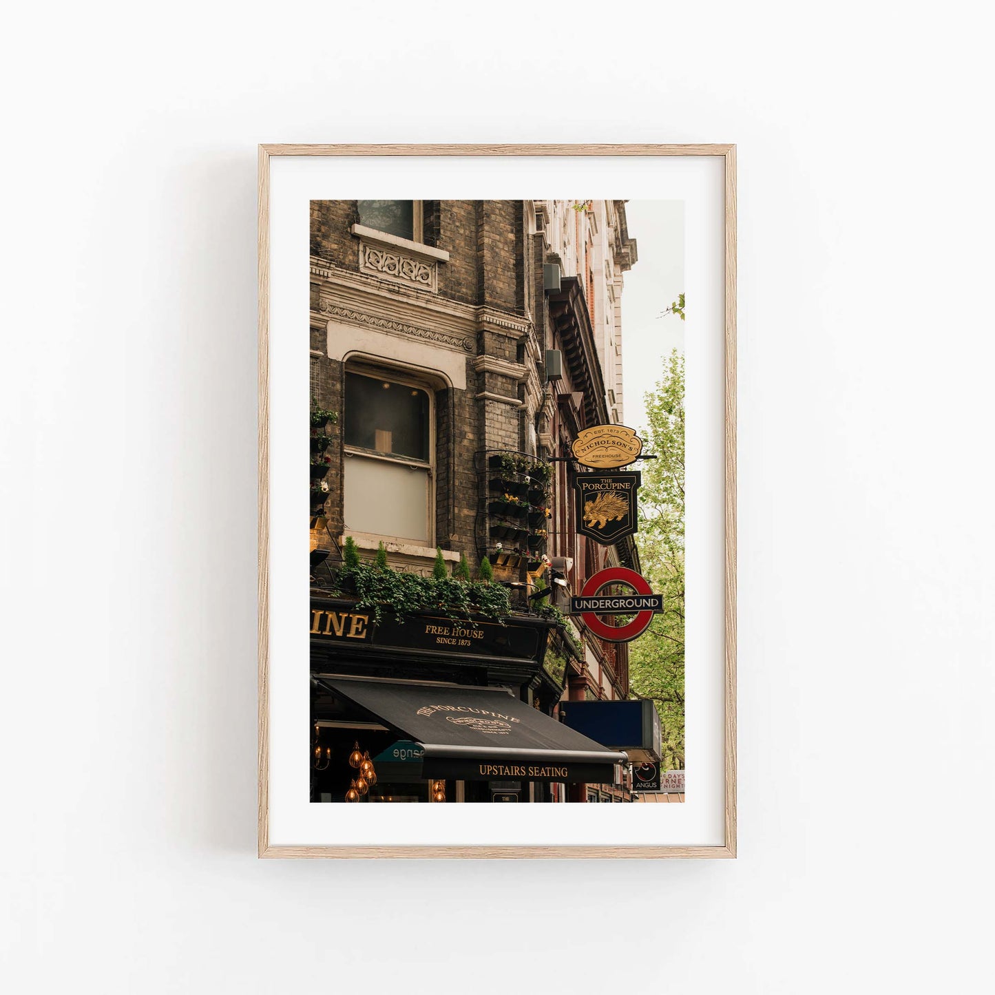 Framed photo of The Porcupine Pub with London Underground sign and historic buildings on a white wall.