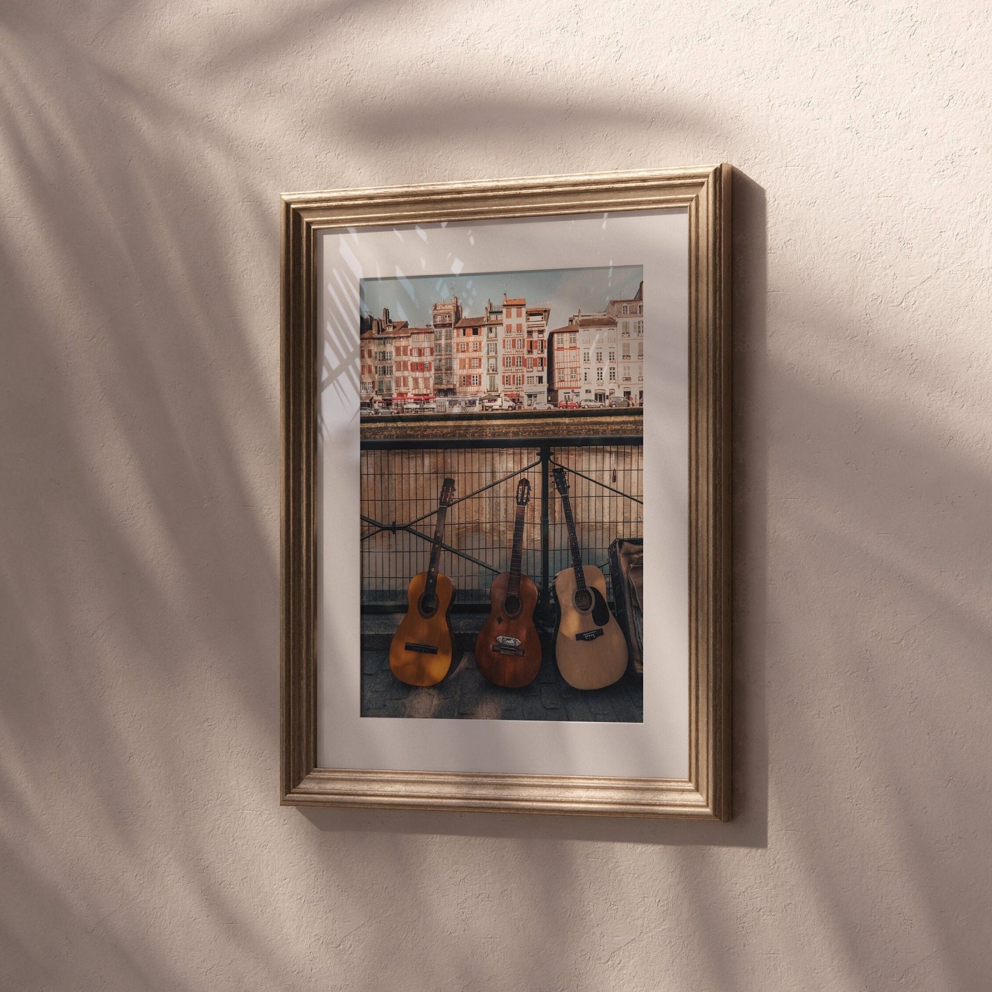 Three Guitars: A framed photo of guitars by a cityscape hangs on a textured wall.