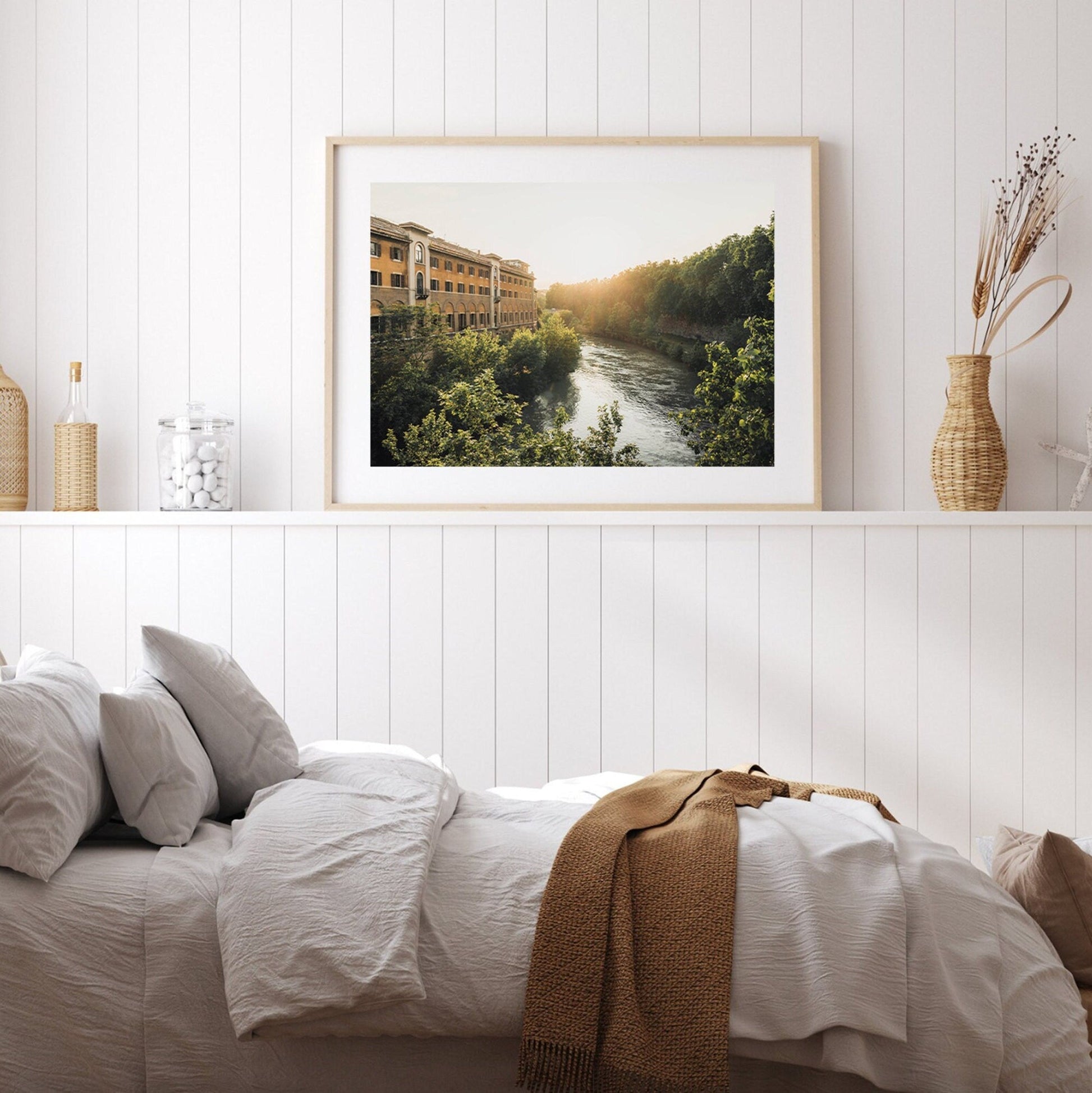 Cozy bedroom with white walls, a bed, and Tiber Island Glow II above a shelf with decorative vases.