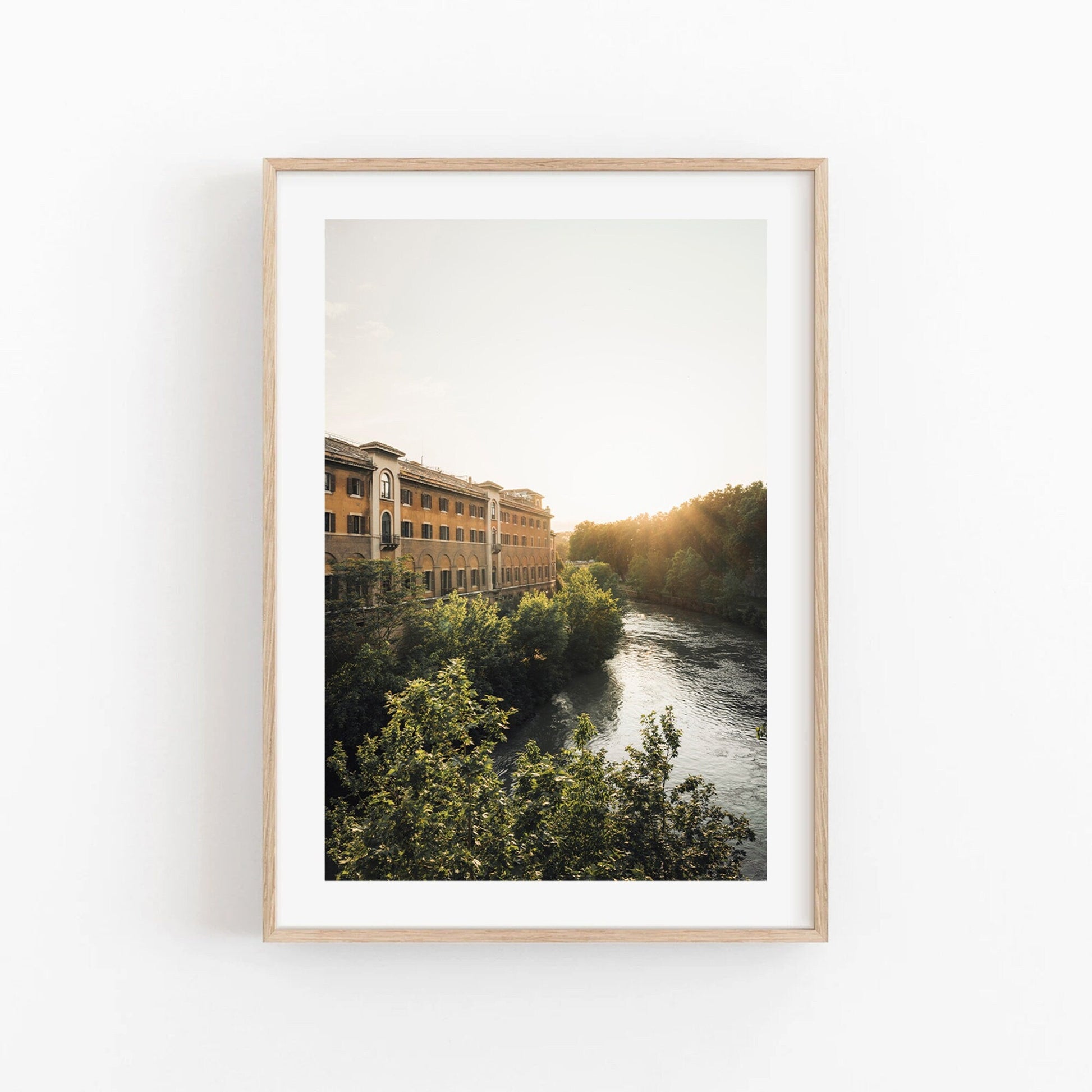 Tiber Island Glow: Framed photo of a riverside building at sunset, surrounded by trees and a flowing river.