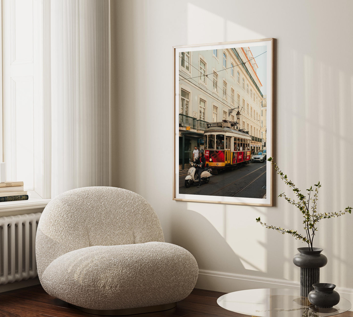 The Tram 28 framed photo hangs above a cozy white chair in a modern living room.