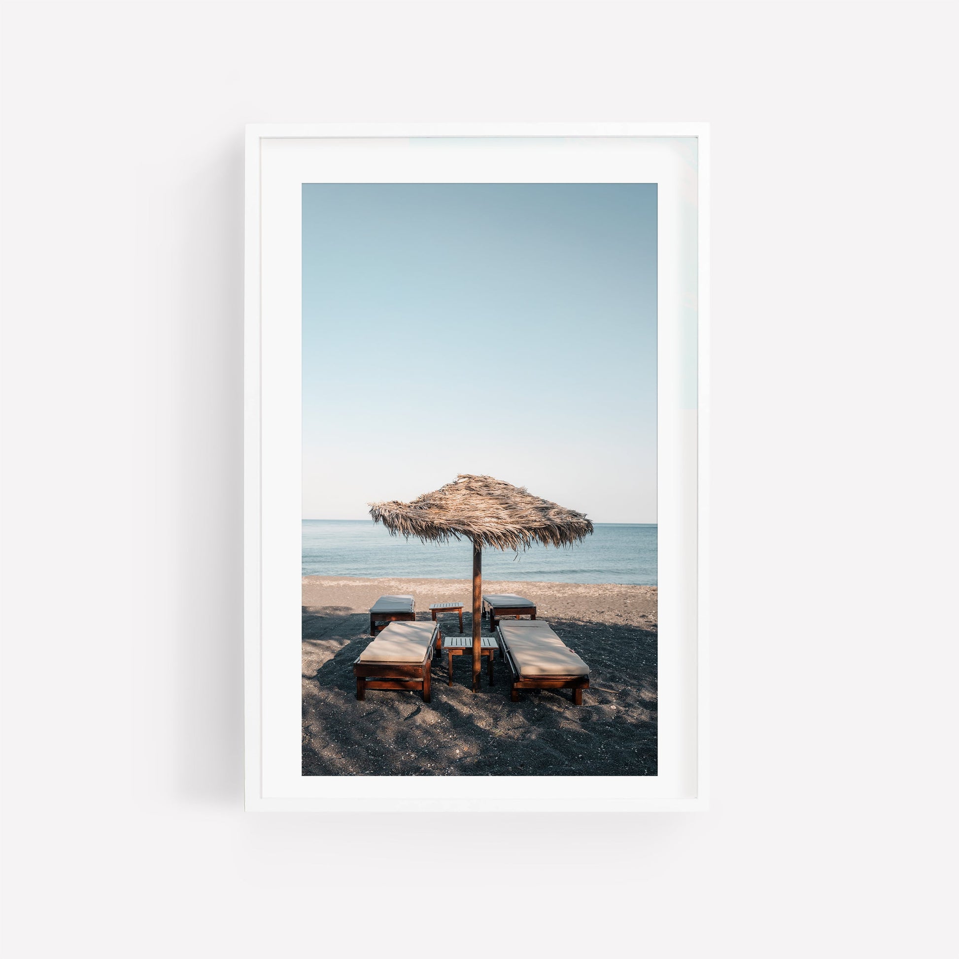 Tranquil Shade: Framed beach photo with four lounge chairs under a straw umbrella facing the calm sea.