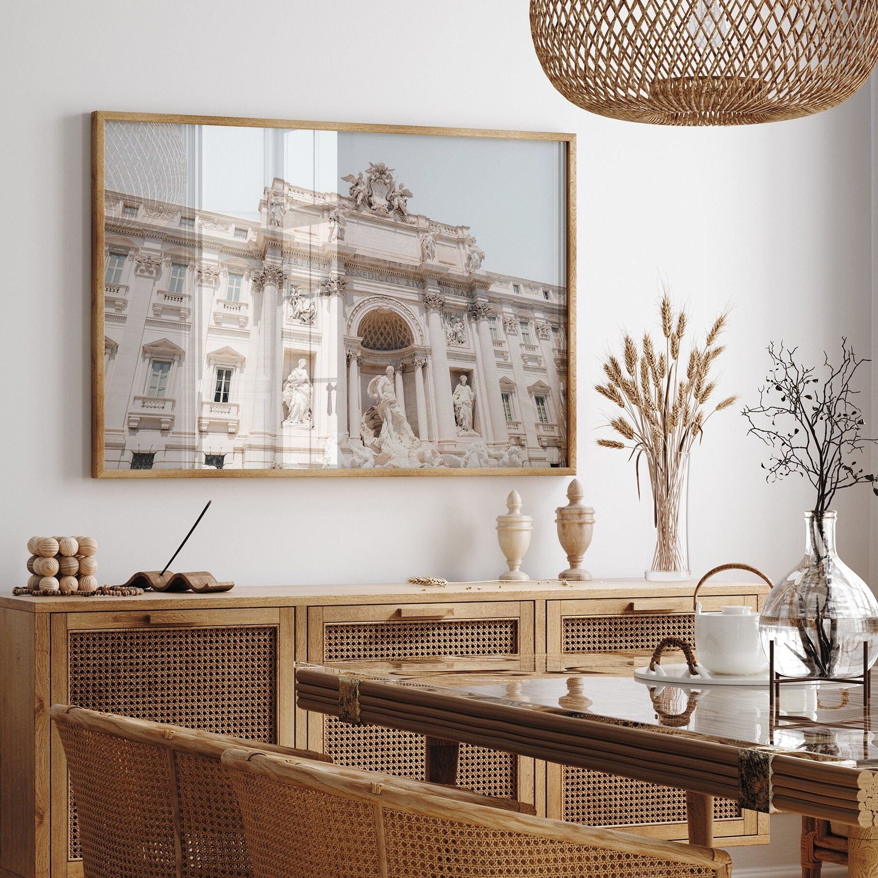 Dining room with wood furniture, a woven light fixture, and the Trevi Fountain framed photo on the wall.