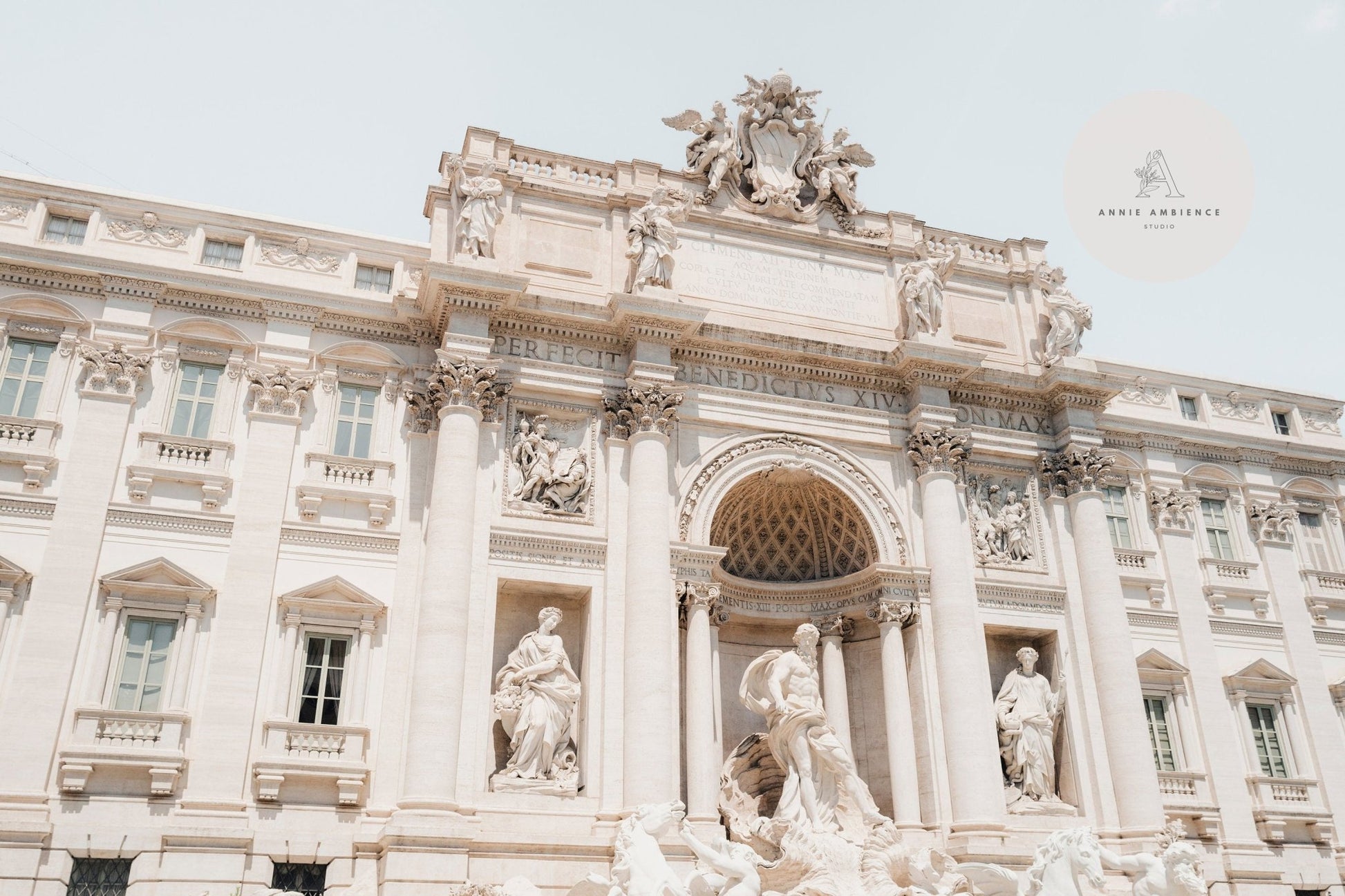 The Trevi Fountain in Rome, Italy, features ornate sculptures and architectural details beneath a clear sky.