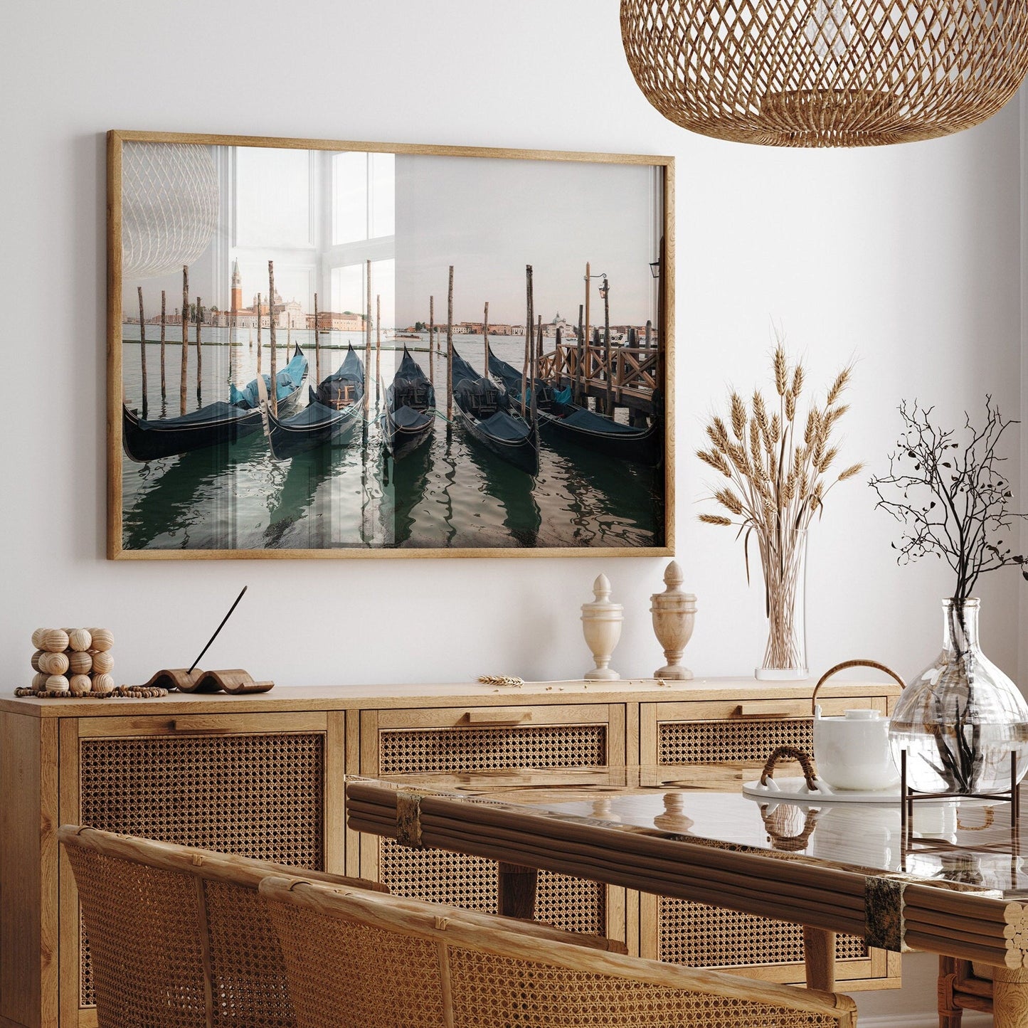Dining room with Venetian Array table, chairs, gondola photo on wall, and dried plants decorating the space.