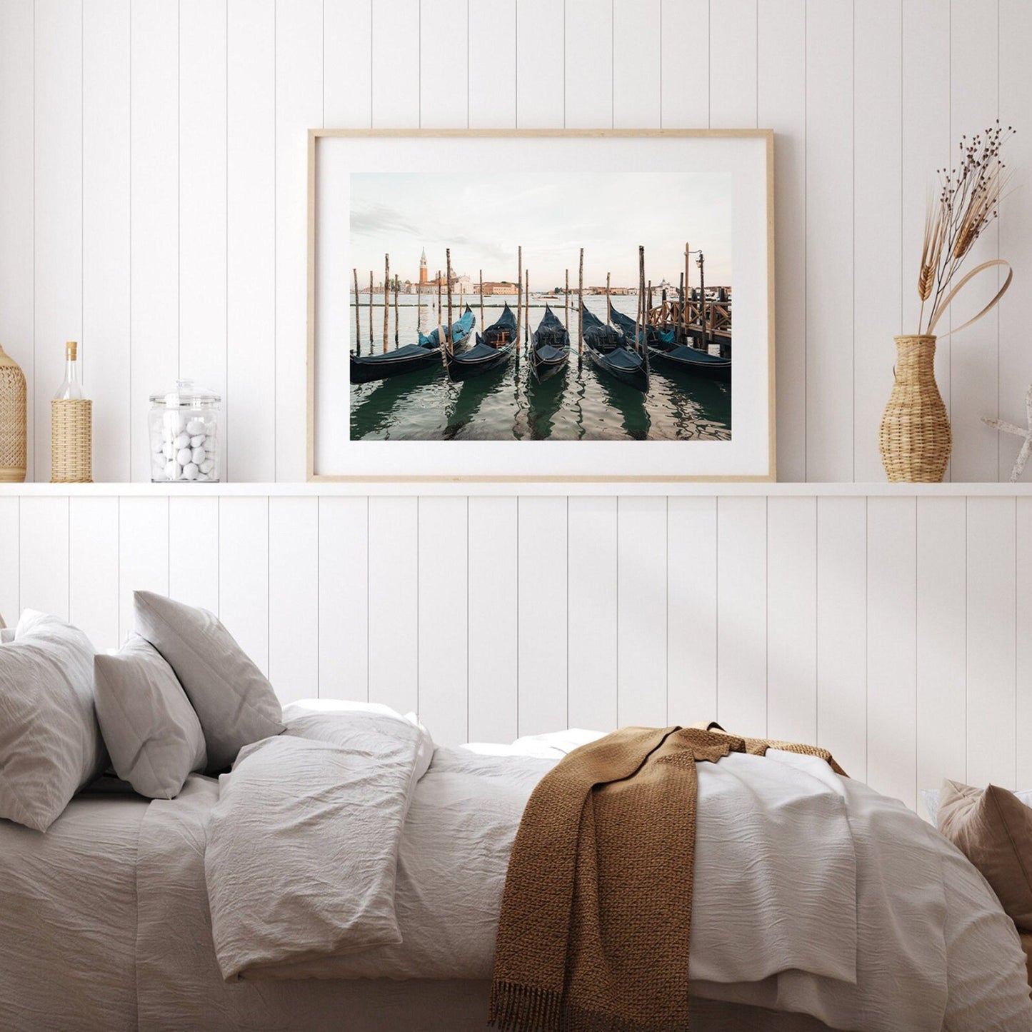 Bedroom with white decor featuring the Venetian Array framed photo of gondolas above a bed with a brown throw blanket.