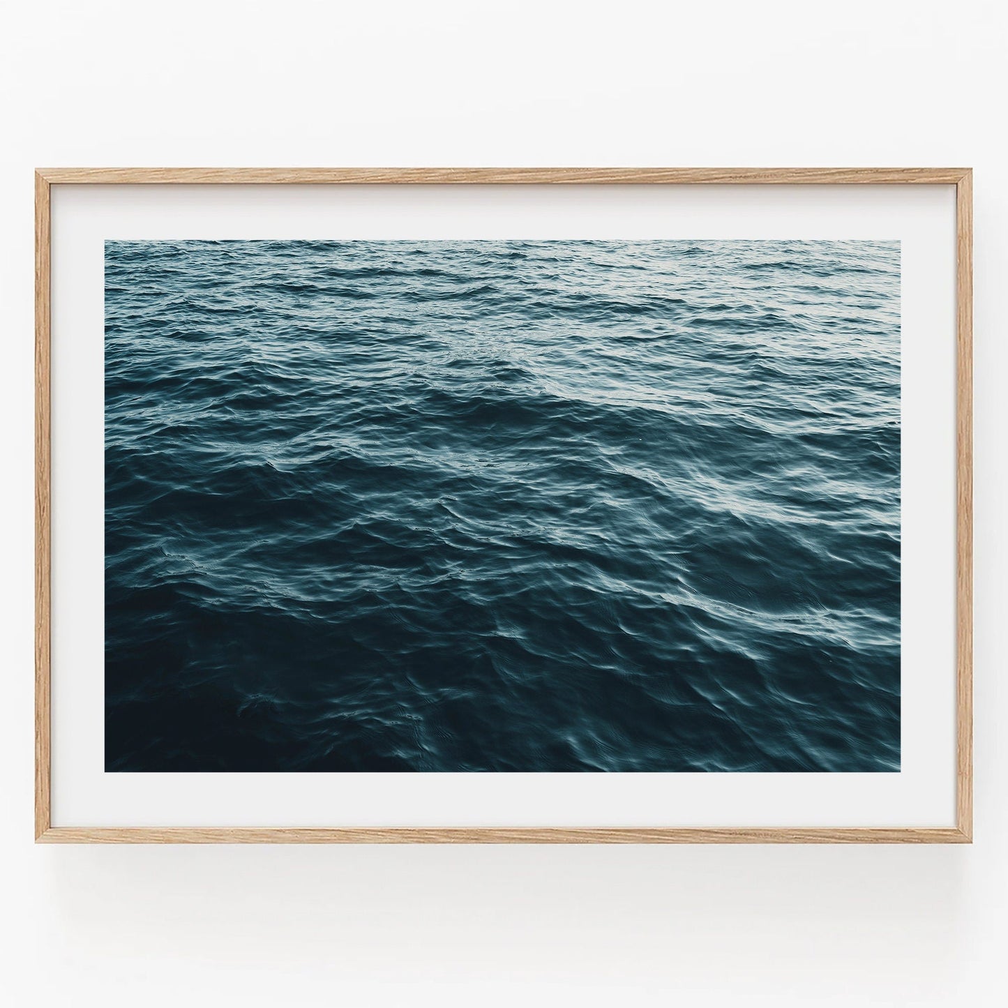 Product: Water Ripples I - A photo of calm ocean waves under a serene sky in a simple wooden frame.