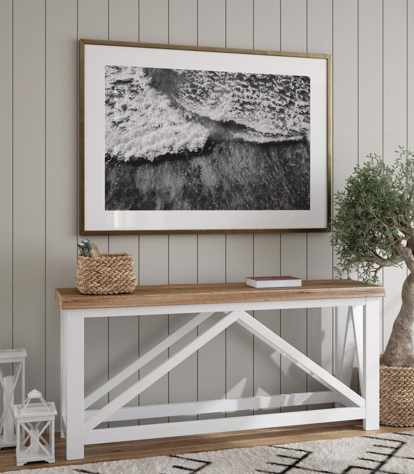 A coastal-themed room with Wave Rush Black and White, a wooden table, woven basket, and potted olive tree.