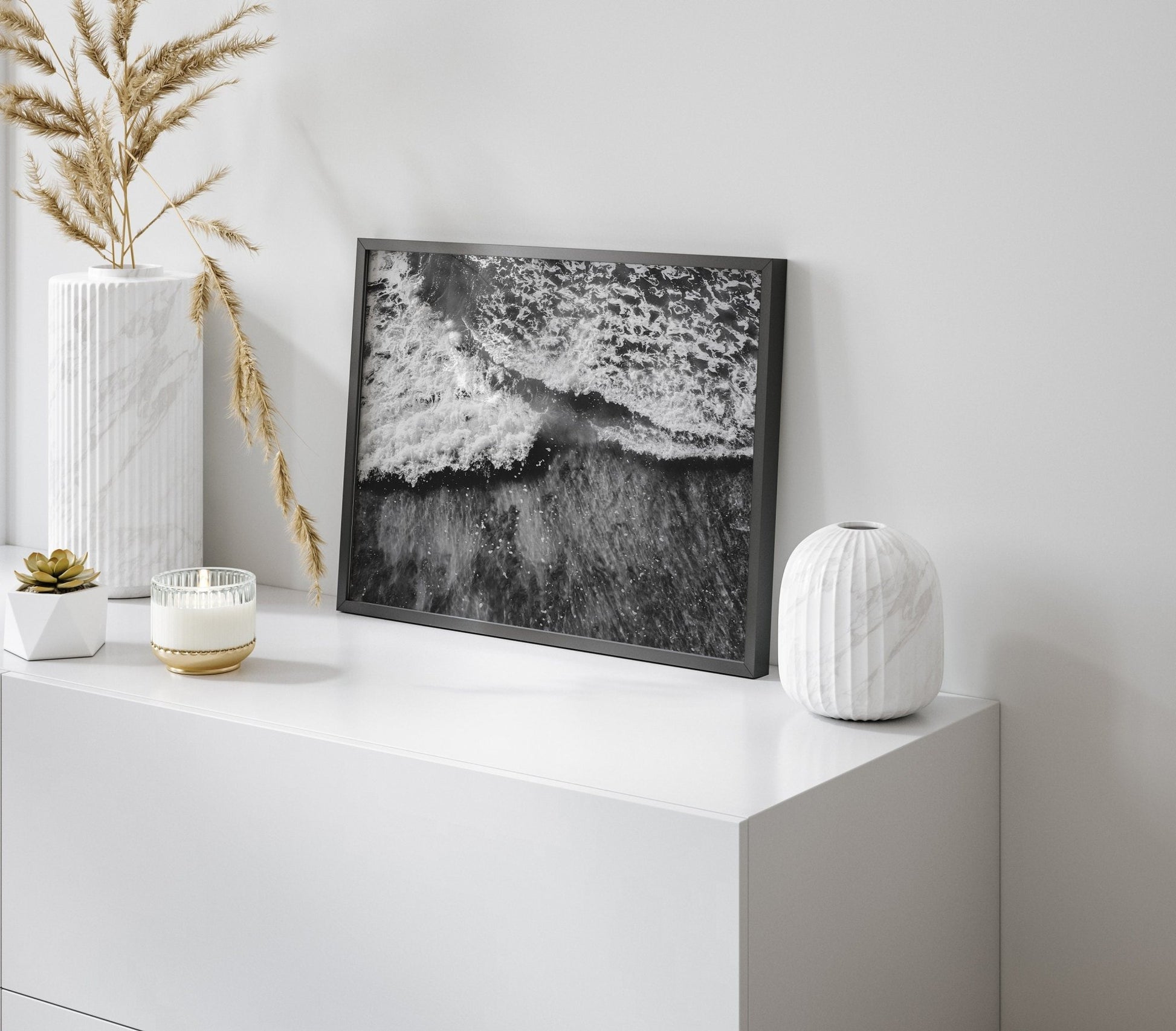 Wave Rush Black and White on a white shelf with vases and a plant beside it.
