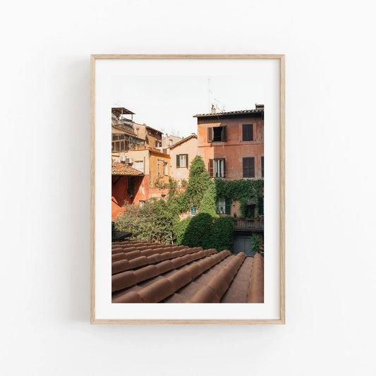 Framed Woke Up in Rome photo of a rustic town with vine-covered buildings and clay rooftops.
