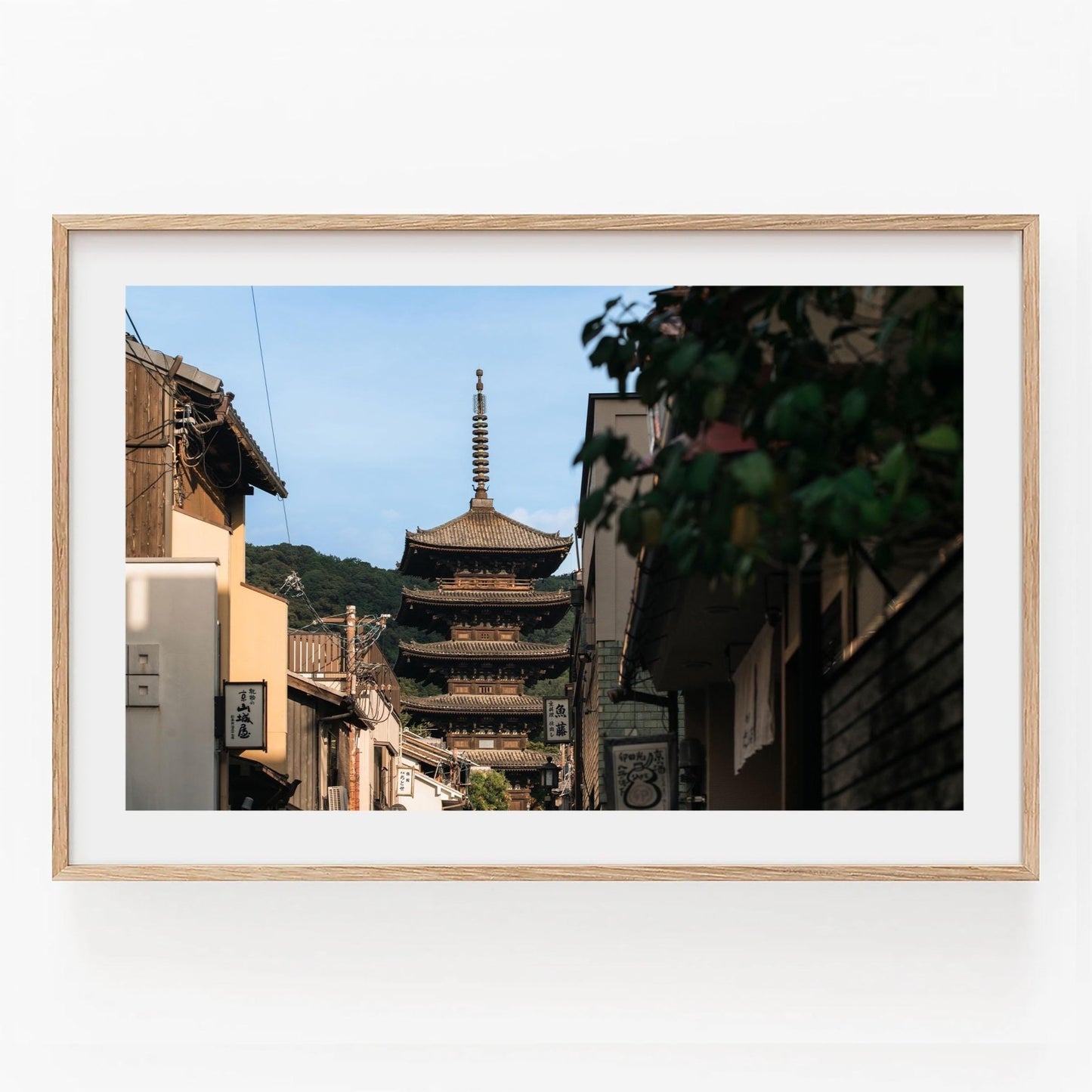 Framed photo titled Yasaka Splendor, capturing a traditional Japanese pagoda through a narrow street with historic buildings.