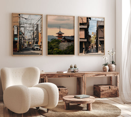 A cozy living room with a plush chair and Kyoto Allure - Set of 3 cityscape photos above a wooden console table.