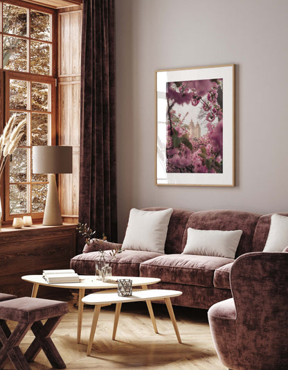 Elegant living room with mauve velvet sofa, light wood tables, large window, and Cherry Blossom II artwork on the wall.