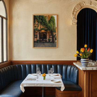 Cozy restaurant booth with blue seats, set table, tulips, and Green Vines Trastevere photo on the wall.