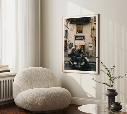 Photograph of motorcycle blurred with speed on the streets of Florence, Italy in a beige frame against a minimalist home decor.