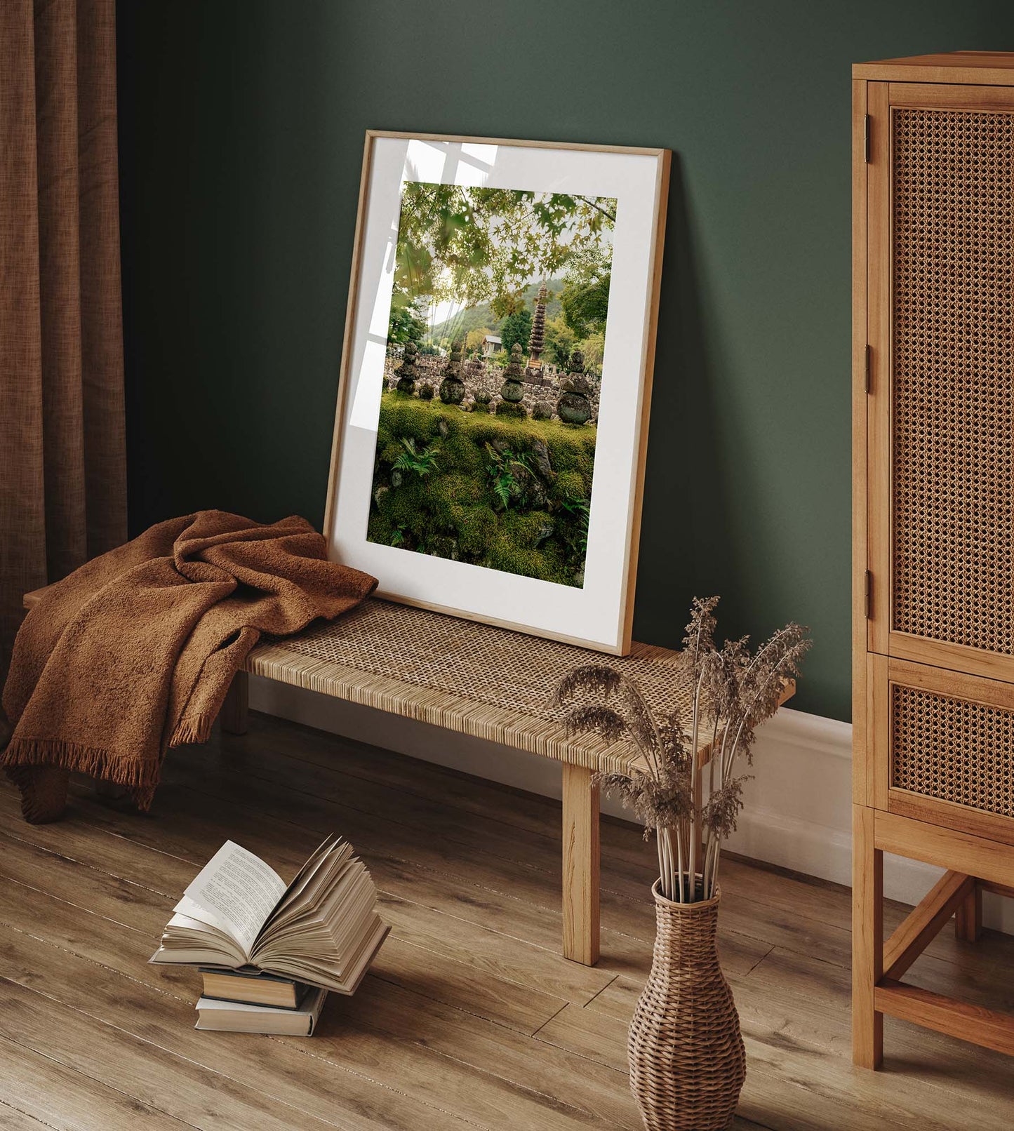 The Adashino Nenbutsu-ji artwork is on a woven bench, with an open book and vase on the floor against a green wall.