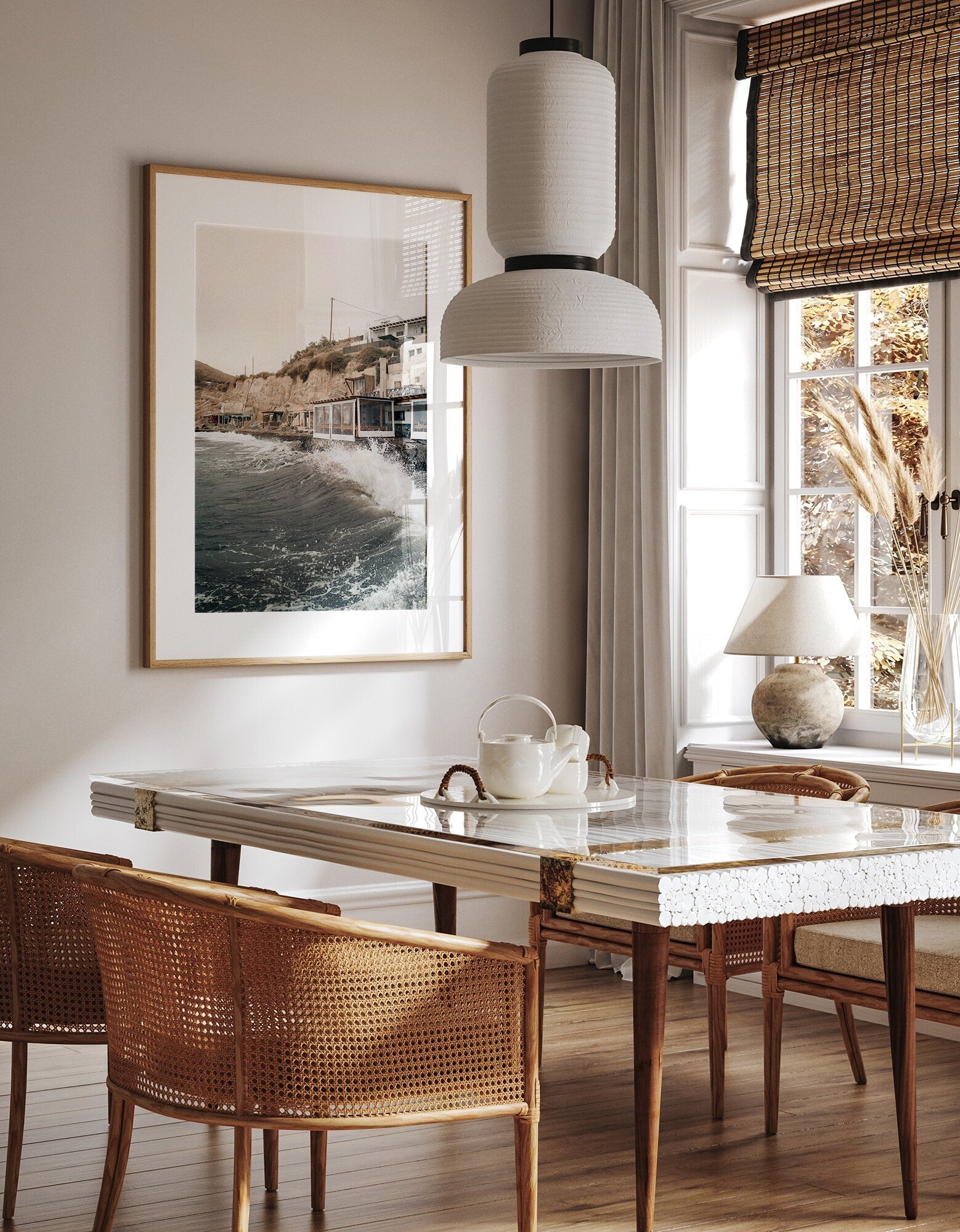 Cozy dining room with a wooden table, cane chairs, a pendant lamp, and the Akrotiri Wave photograph on the wall.