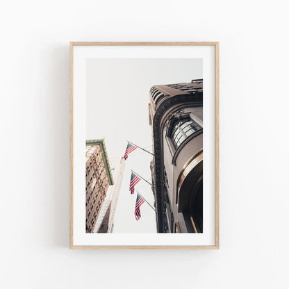 Framed American Pride photo shows city buildings from below, highlighted by multiple American flags and a clear sky.