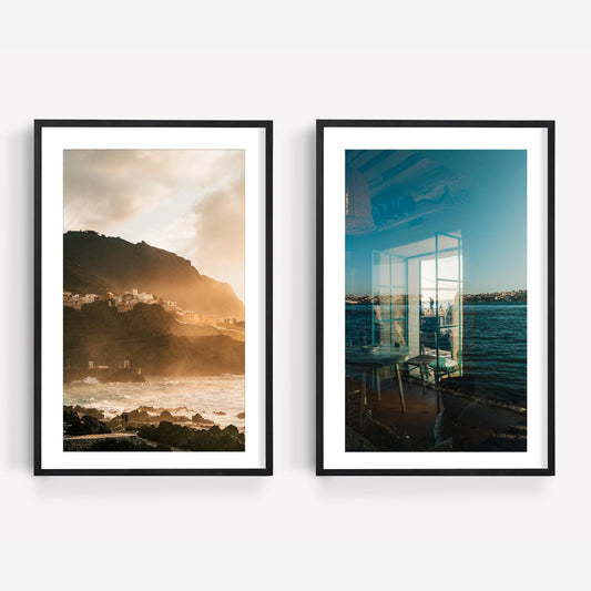 Atmospheric Coasts - Set of 2: framed prints show a coastal village at sunset and a seaside view through glass reflections.