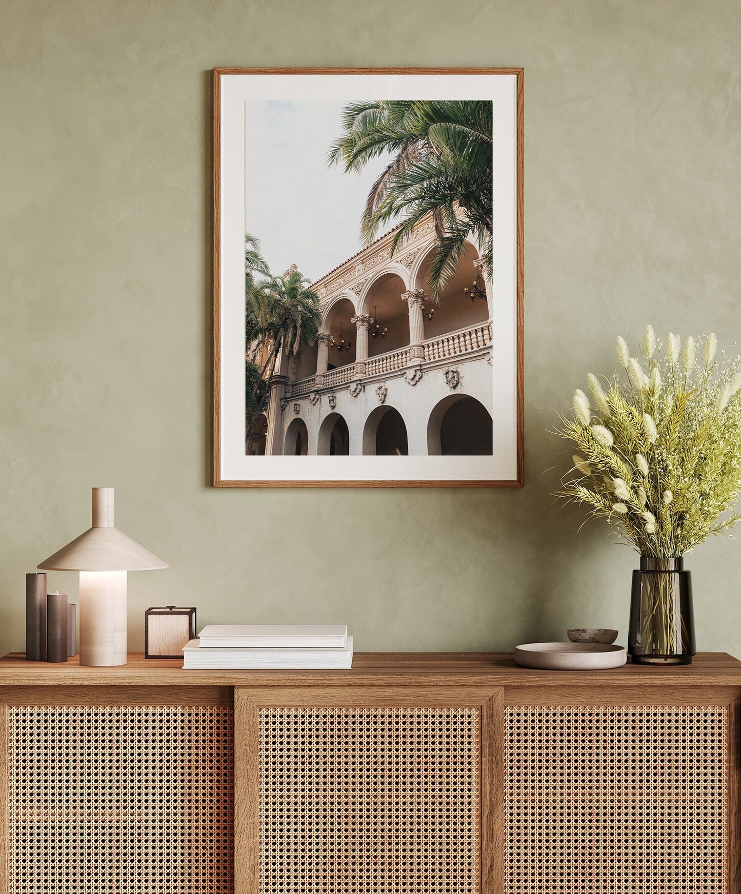 The Balboa Architecture I framed photo hangs above a sideboard with decor and a vase of flowers.