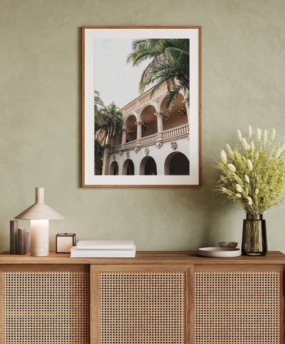 The Balboa Architecture I framed photo hangs above a sideboard with decor and a vase of flowers.