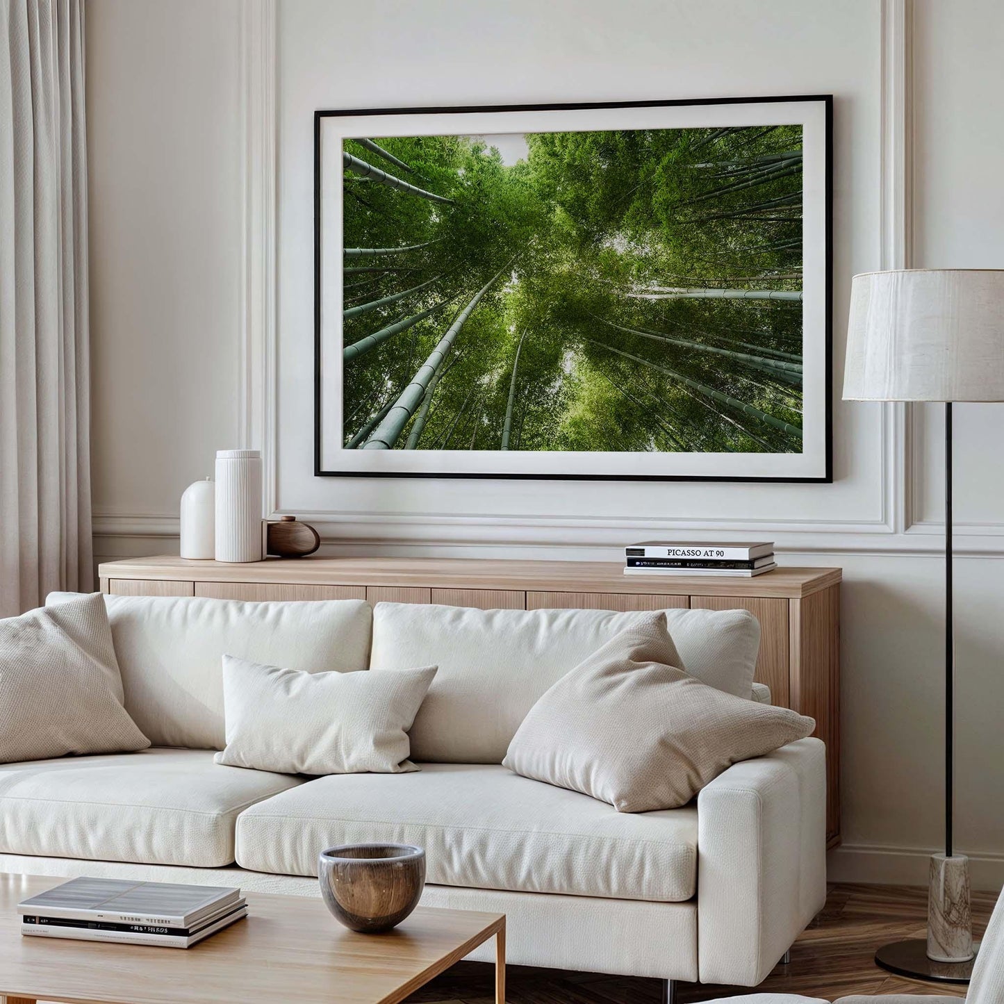 A cozy living room with a white sofa, wooden cabinet, and a framed picture titled Bamboo Forest II on the wall.