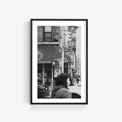 Bayard St. Black and White photo of a bustling city street with a pedestrian, buildings, and traffic signs.