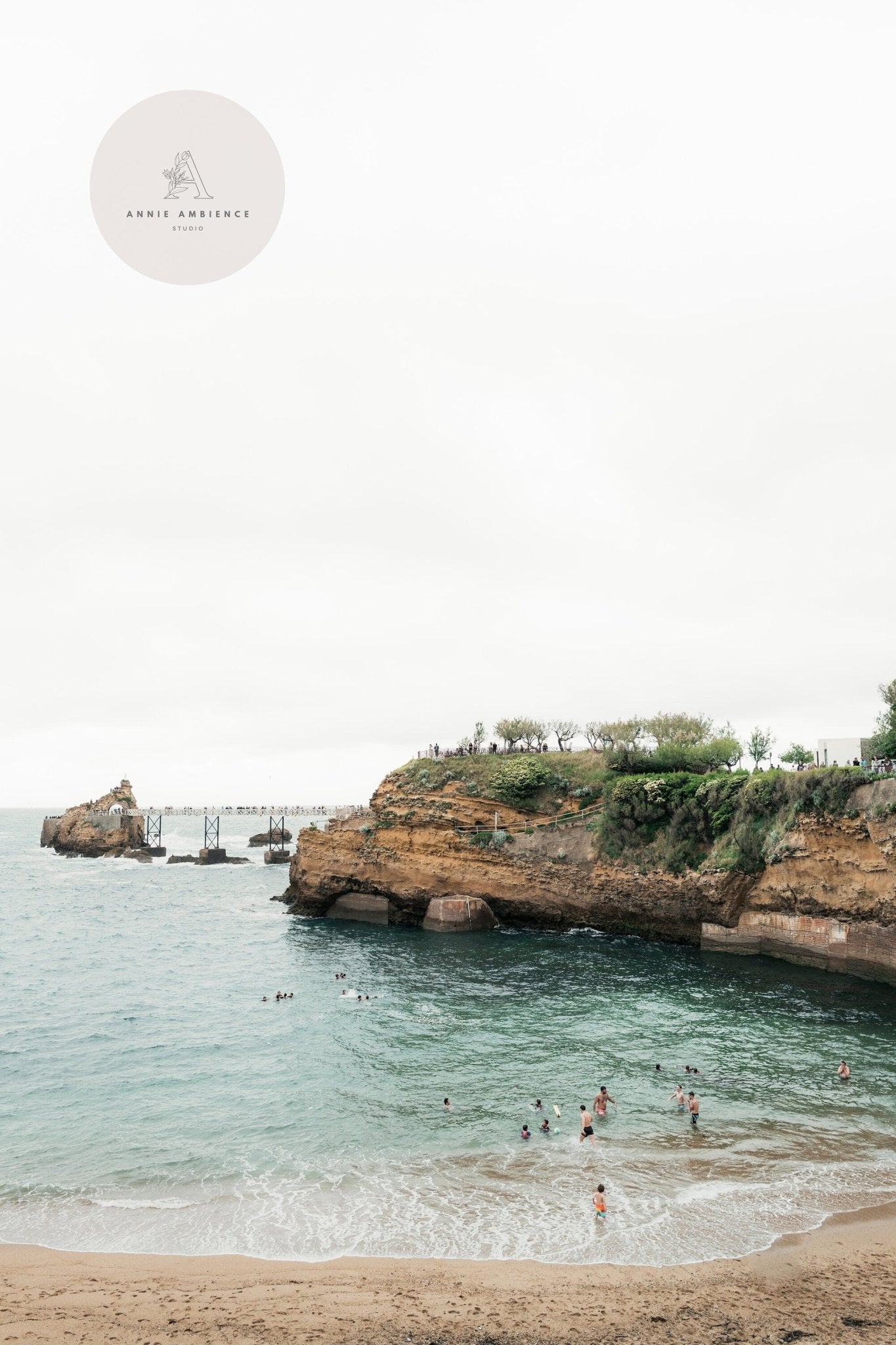 Biarritz Beach II features a beach scene with swimmers and cliff backdrop under a cloudy sky.