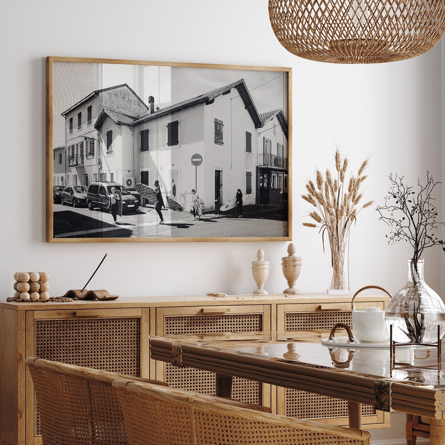 Dining room with wicker furniture and a large framed Biarritz Surfers Black and White photo on the wall.