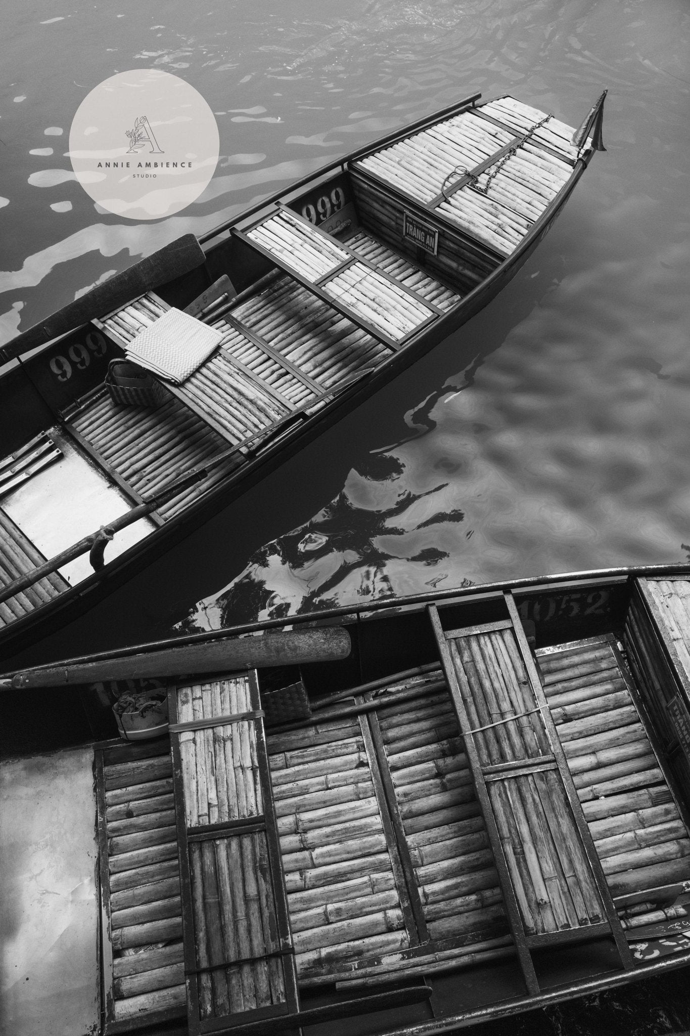 Black and white photo of empty Vietnam bamboo boats on calm water, from the Black and White Vietnam Bamboo - Set of 3.