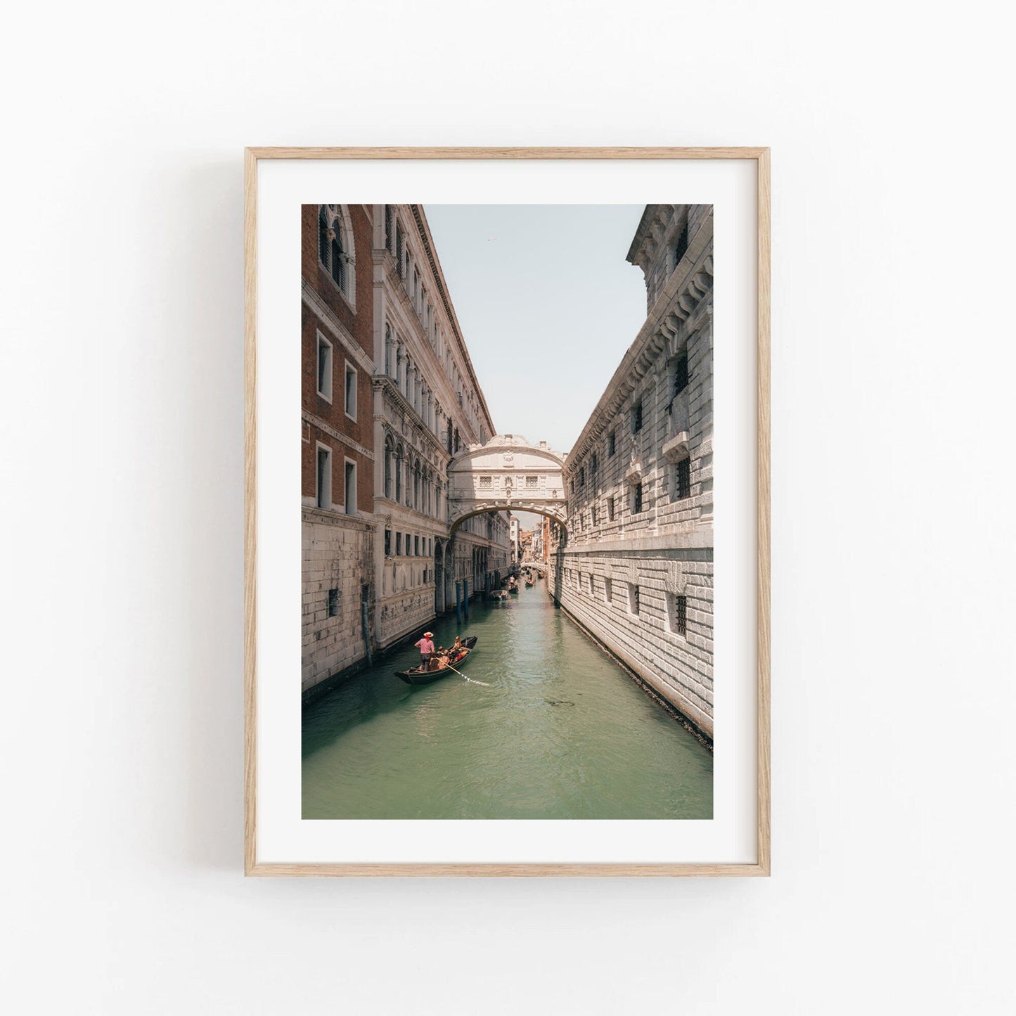 Framed photo of the Bridge of Sighs in Venice, featuring a gondola on a canal amidst historic buildings and an arched bridge.