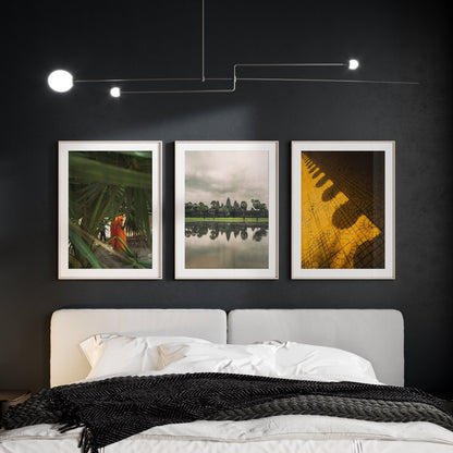 Bedroom with a modern chandelier and the Cambodian Culture - Set of 3 framed pictures above the bed on a dark wall.