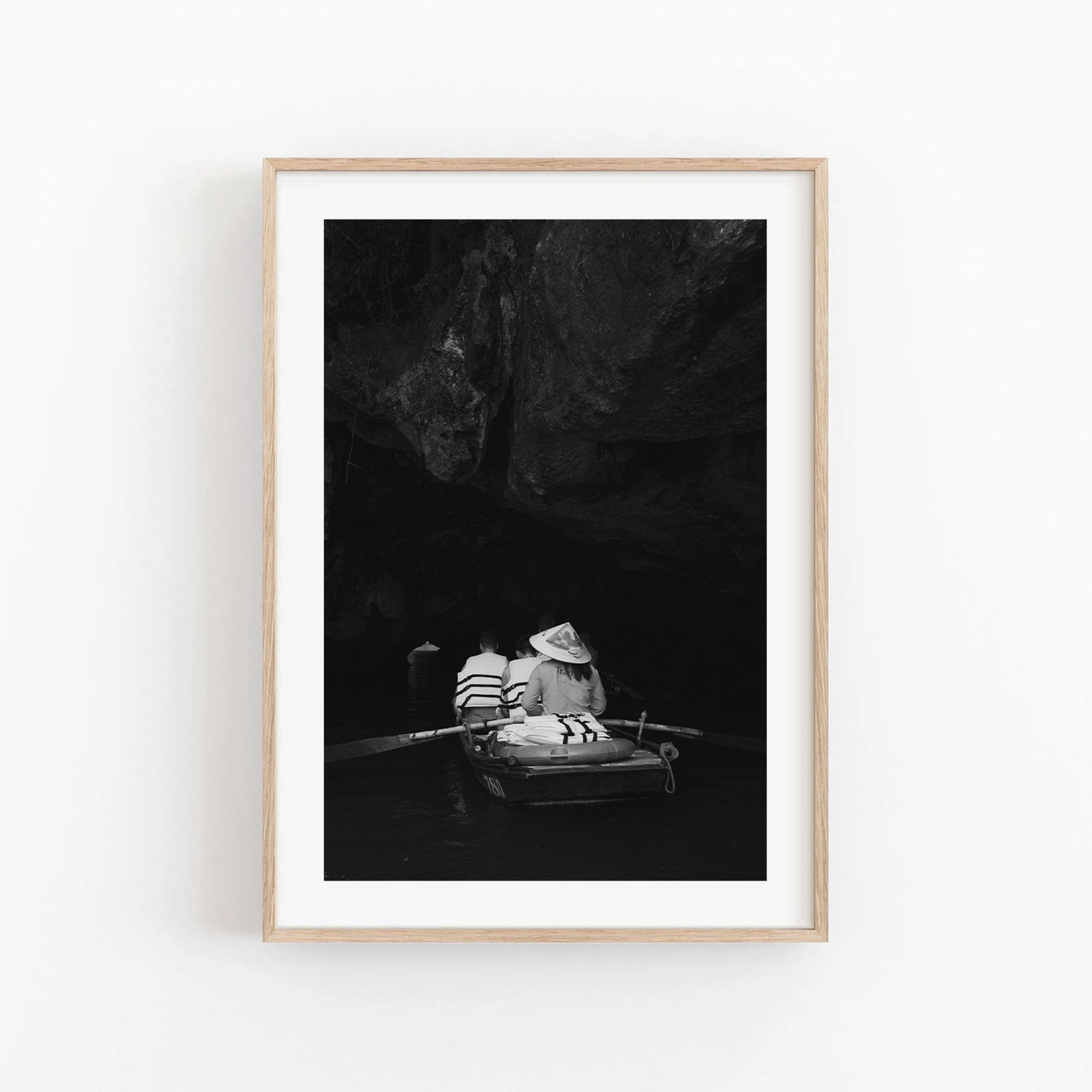 Cave Boat Black and White photo of two rowers in a cave, framed with a light wood border.