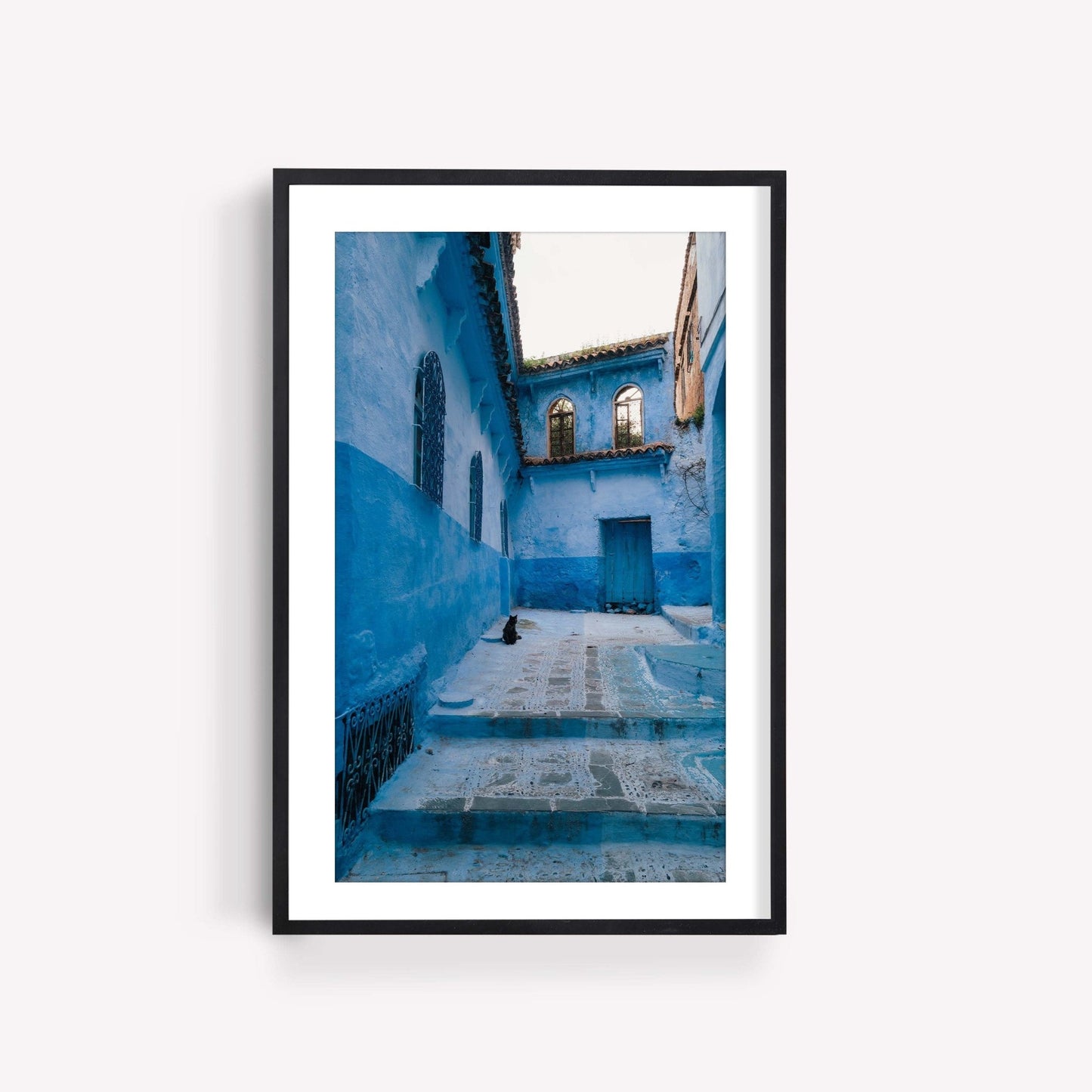 Framed photo titled Chefchaouen Cat depicting a sitting cat in a blue alley.