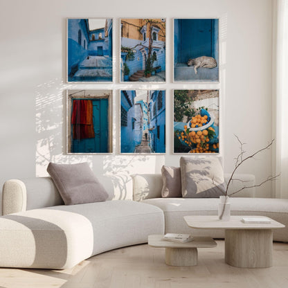 A modern living room with a curved sofa, minimalist decor, and the Chefchaouen - Set of 6 blue-themed street scene photos.