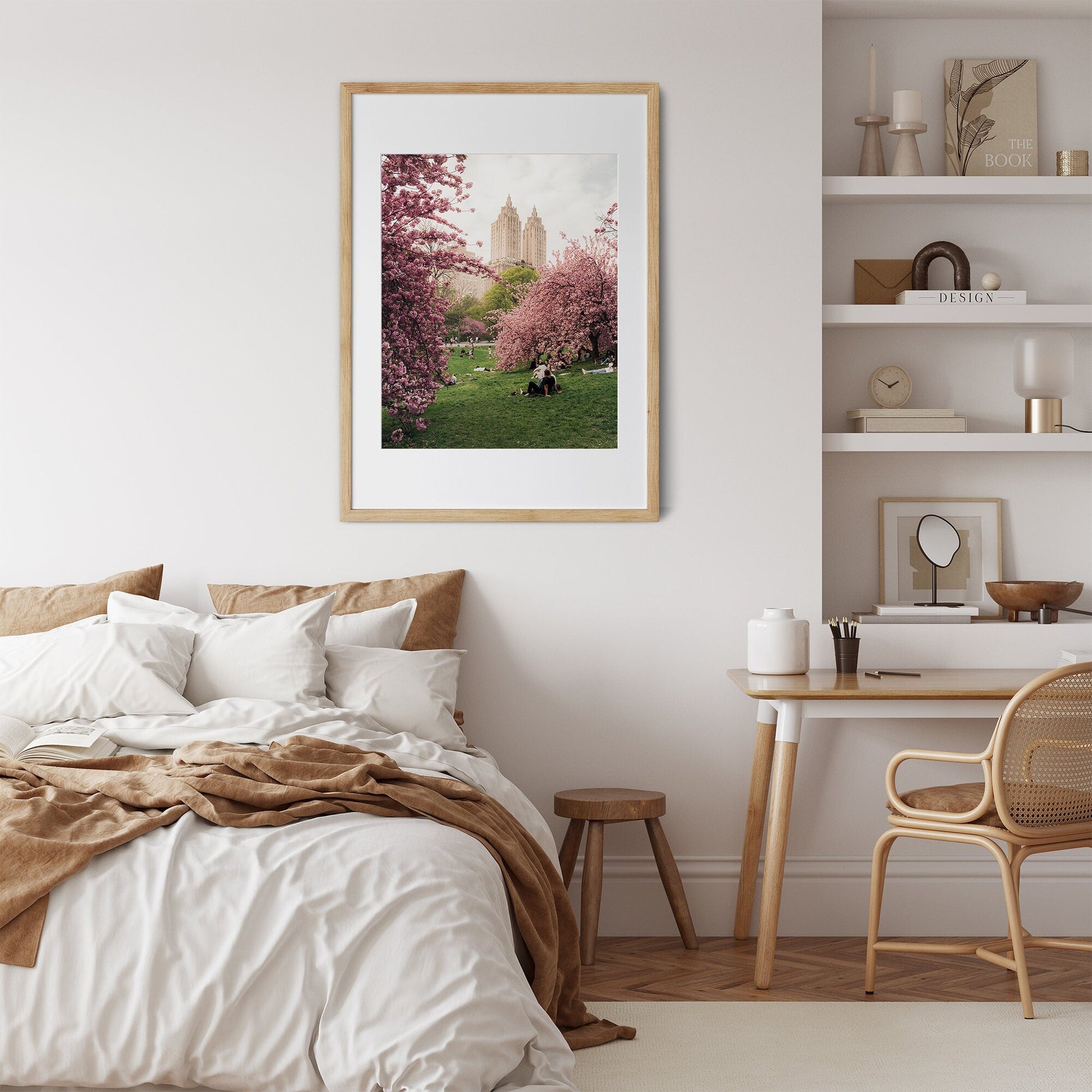 A cozy bedroom with a bed, chair, desk, and Cherry Blossom I artwork on the wall.