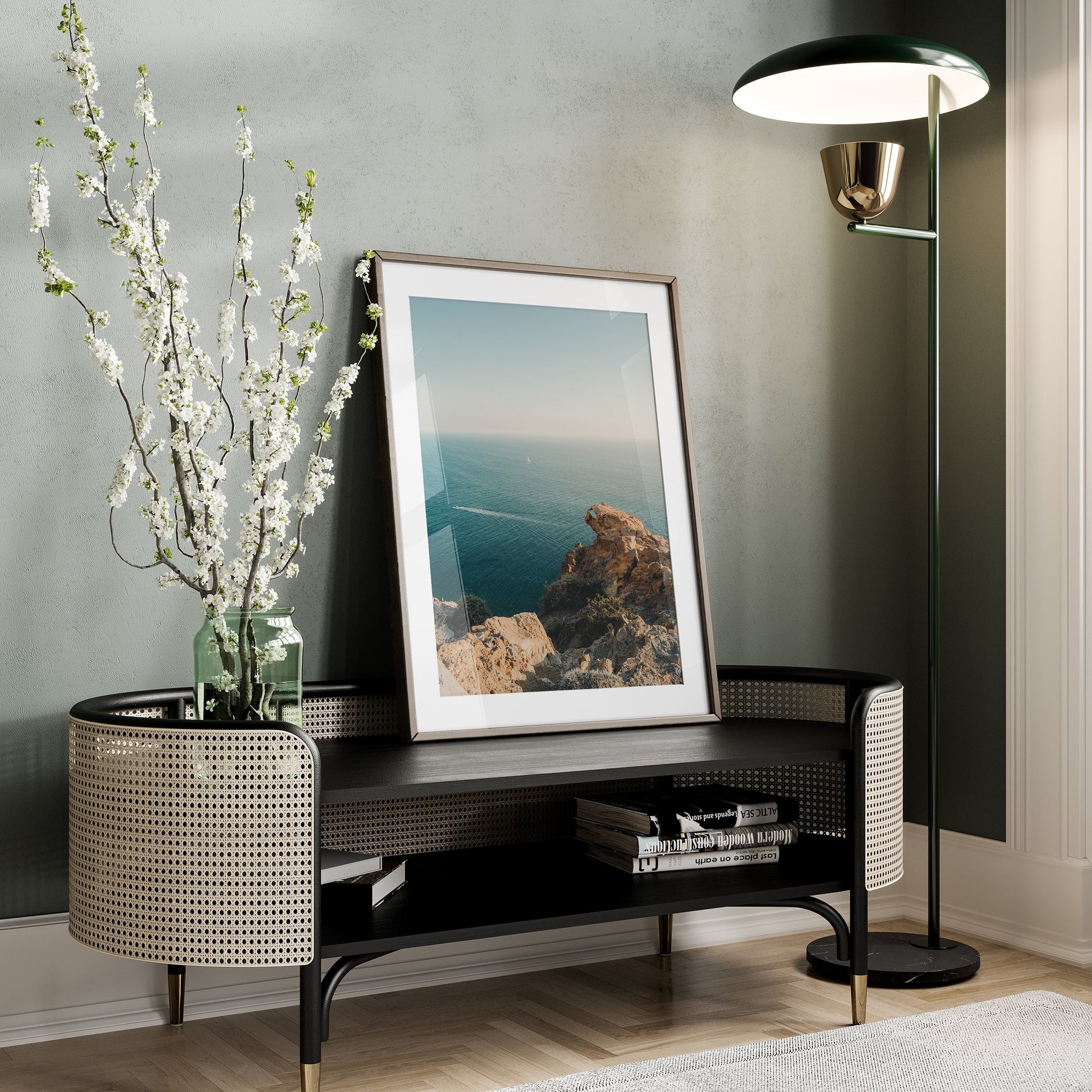 Cliffside Paradise framed photo on a bench with a vase, floor lamp, and books in a modern living room.